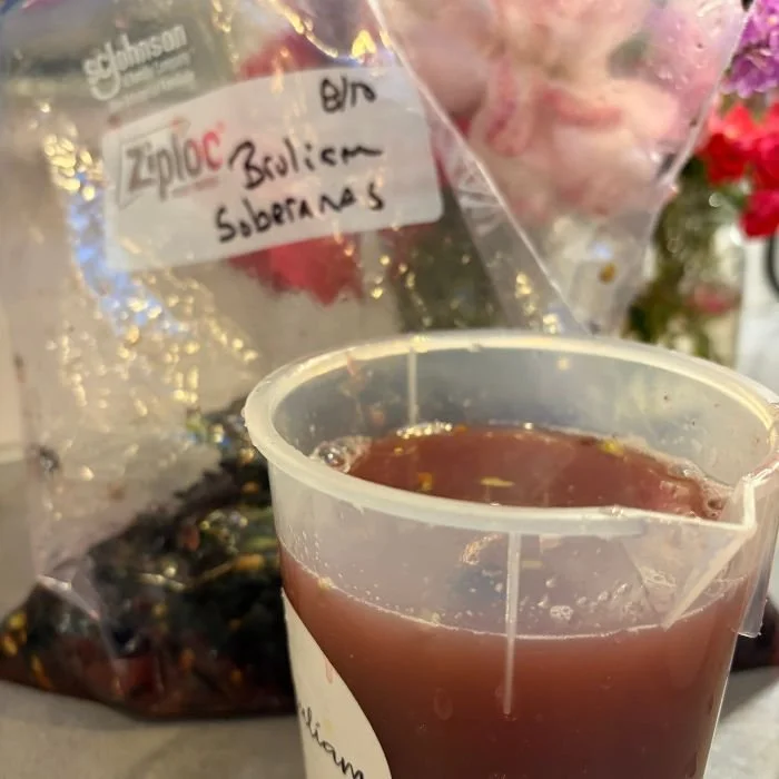 bag of pinot noir grapes from the Soberanes Vineyard in Santa Lucia Highlands with a beaker of fresh grape juice