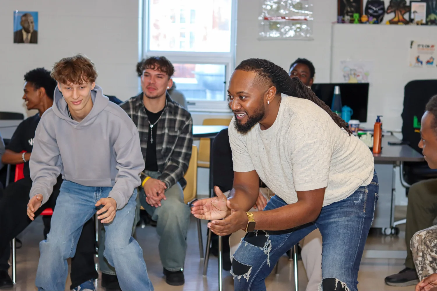 Tune In Foundation mentor leans in to engage young people during a group discussion.