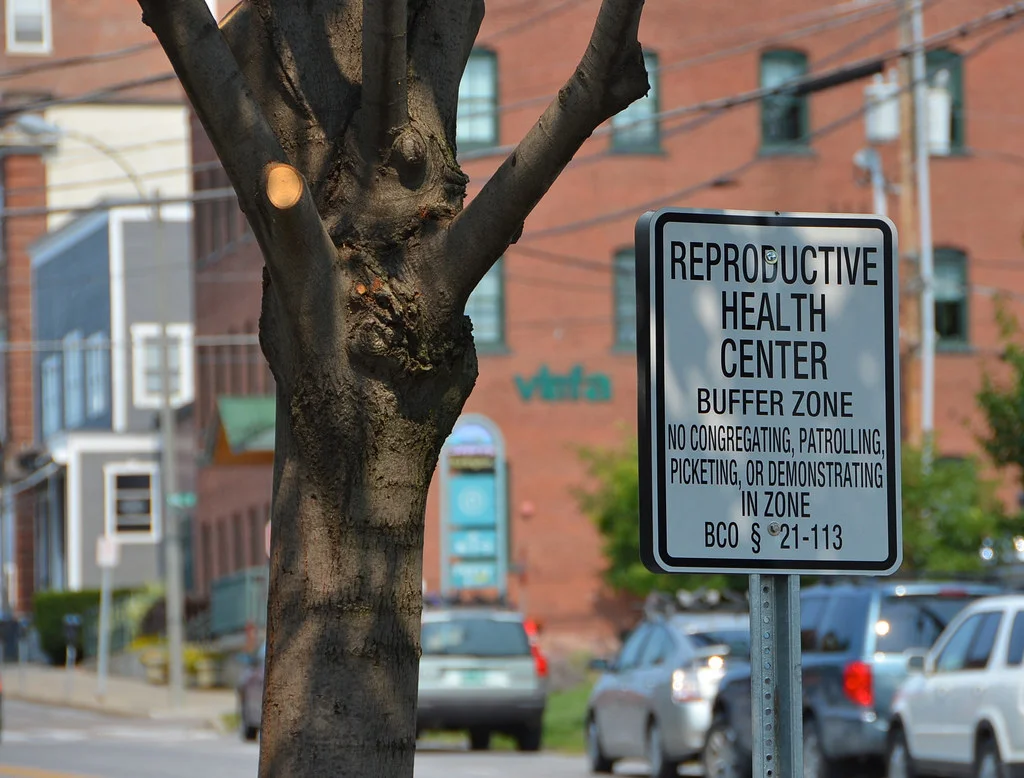 A sign outside a a reproductive health center warning away protestors