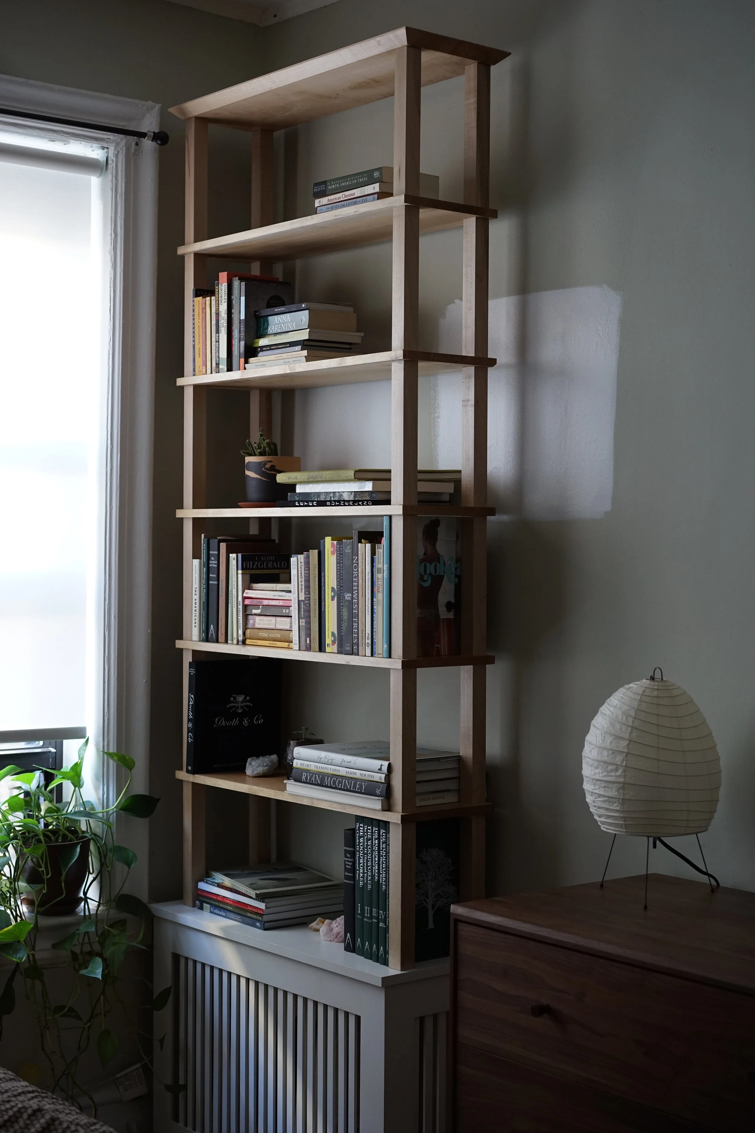  These two bookcases originated out of a need for storage. In NYC everything in your apartment is a balancing act. Since floor space is such a premium, I made freestanding but removable bookcases that sit on top of the radiators in our home.  