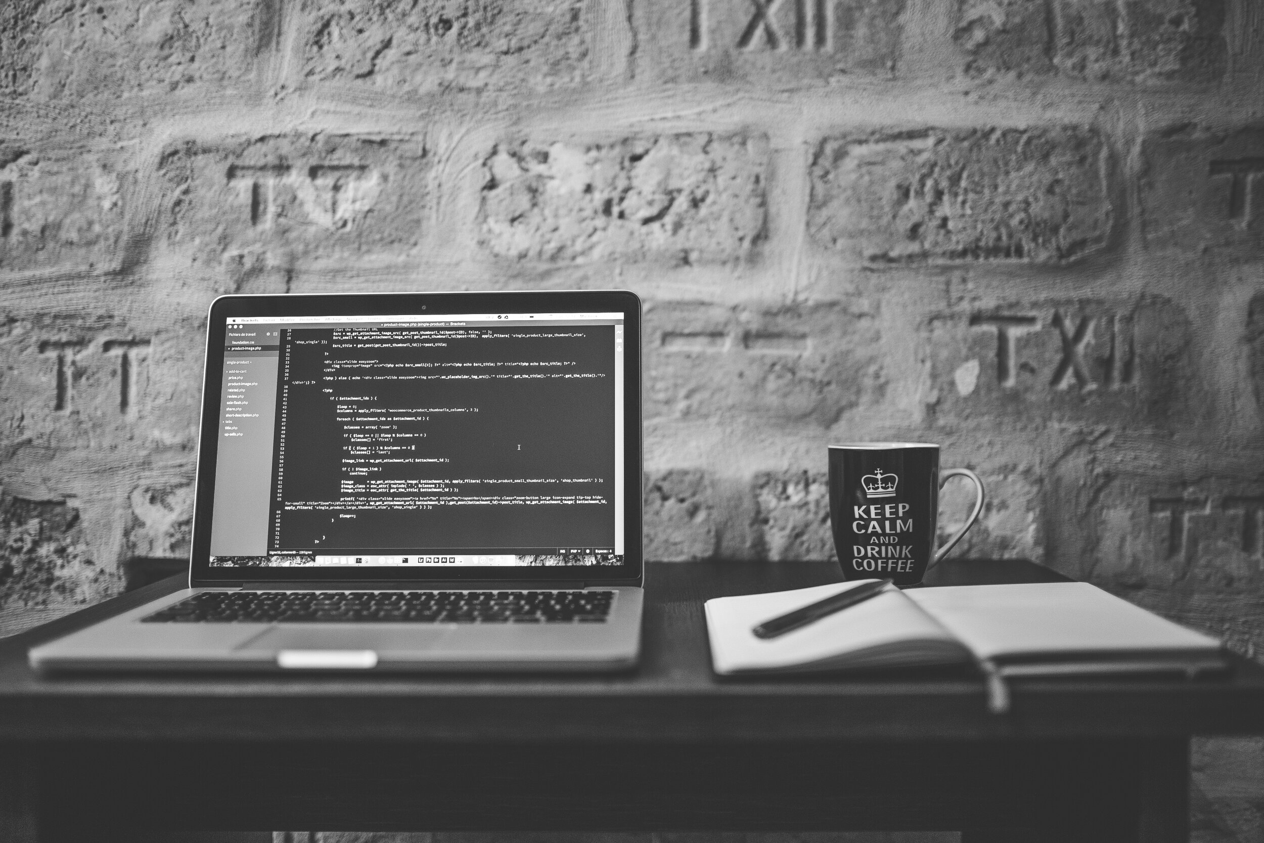 grayscale-photo-of-computer-laptop-near-white-notebook-and-169573.jpg