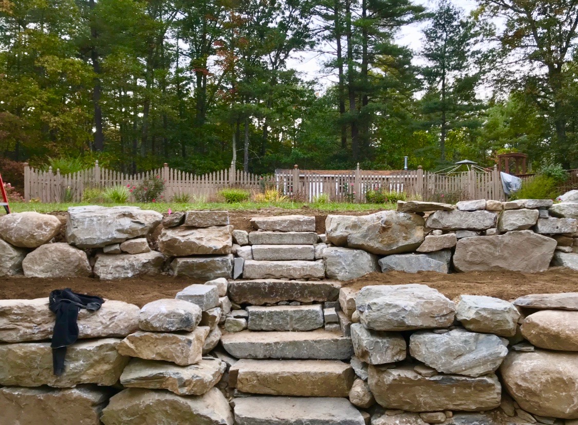 Boulder wall and aged granite steps.