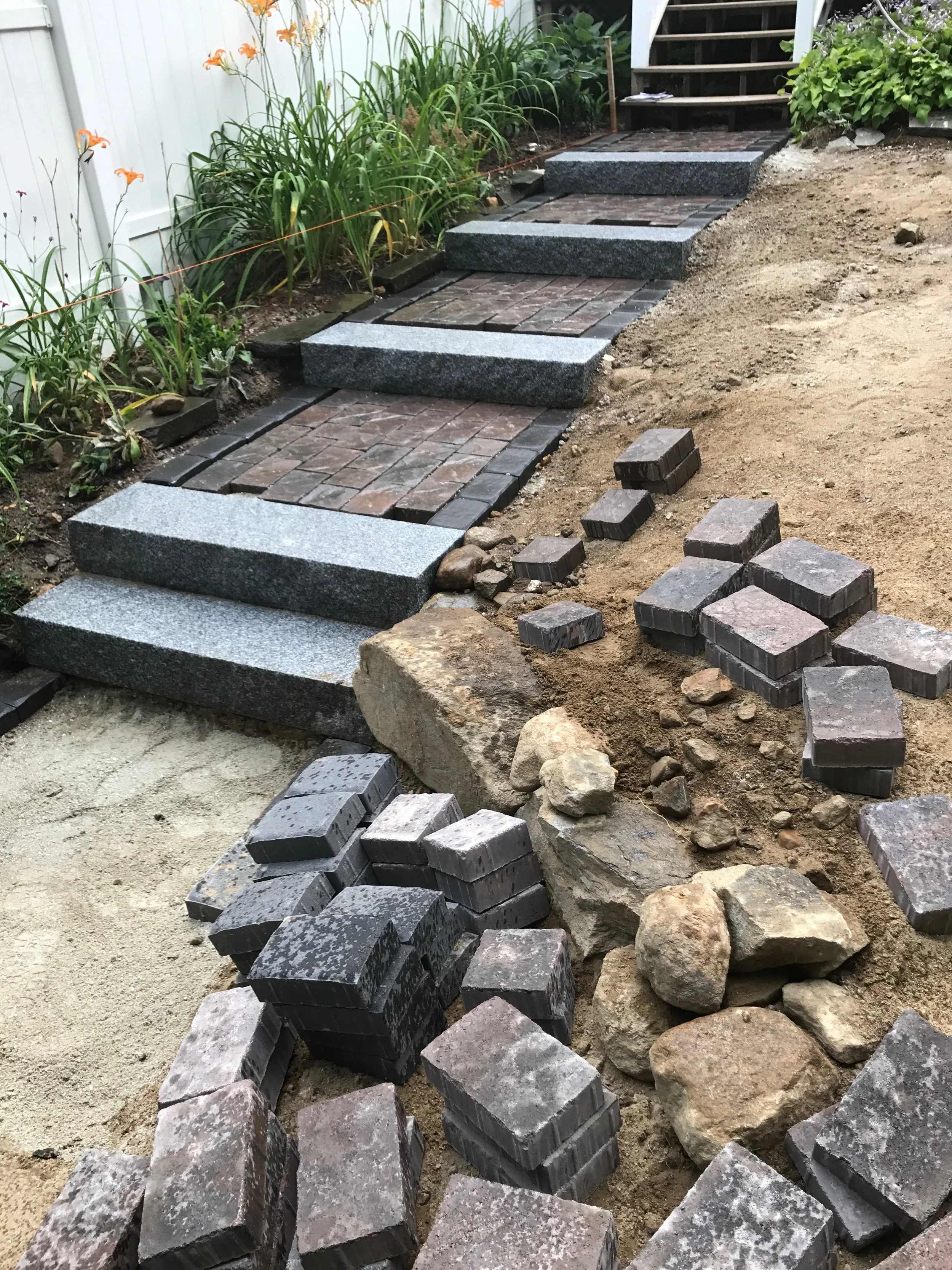 4' granite steps and contrasting brick make this hillside entrance an elegant addition.
