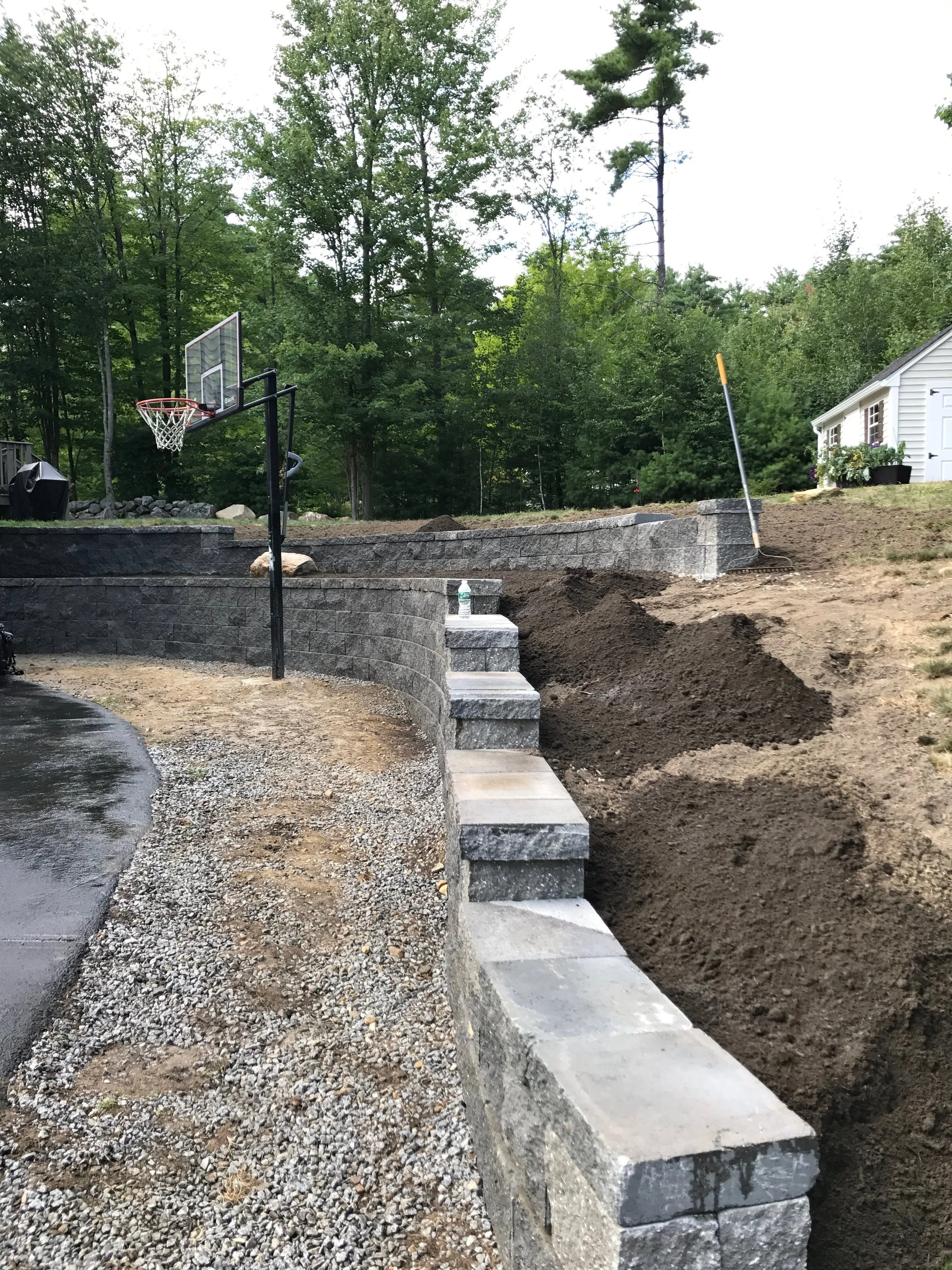 Concrete allen block is used for retaining a hillside and adding gardens and usable lawn space.