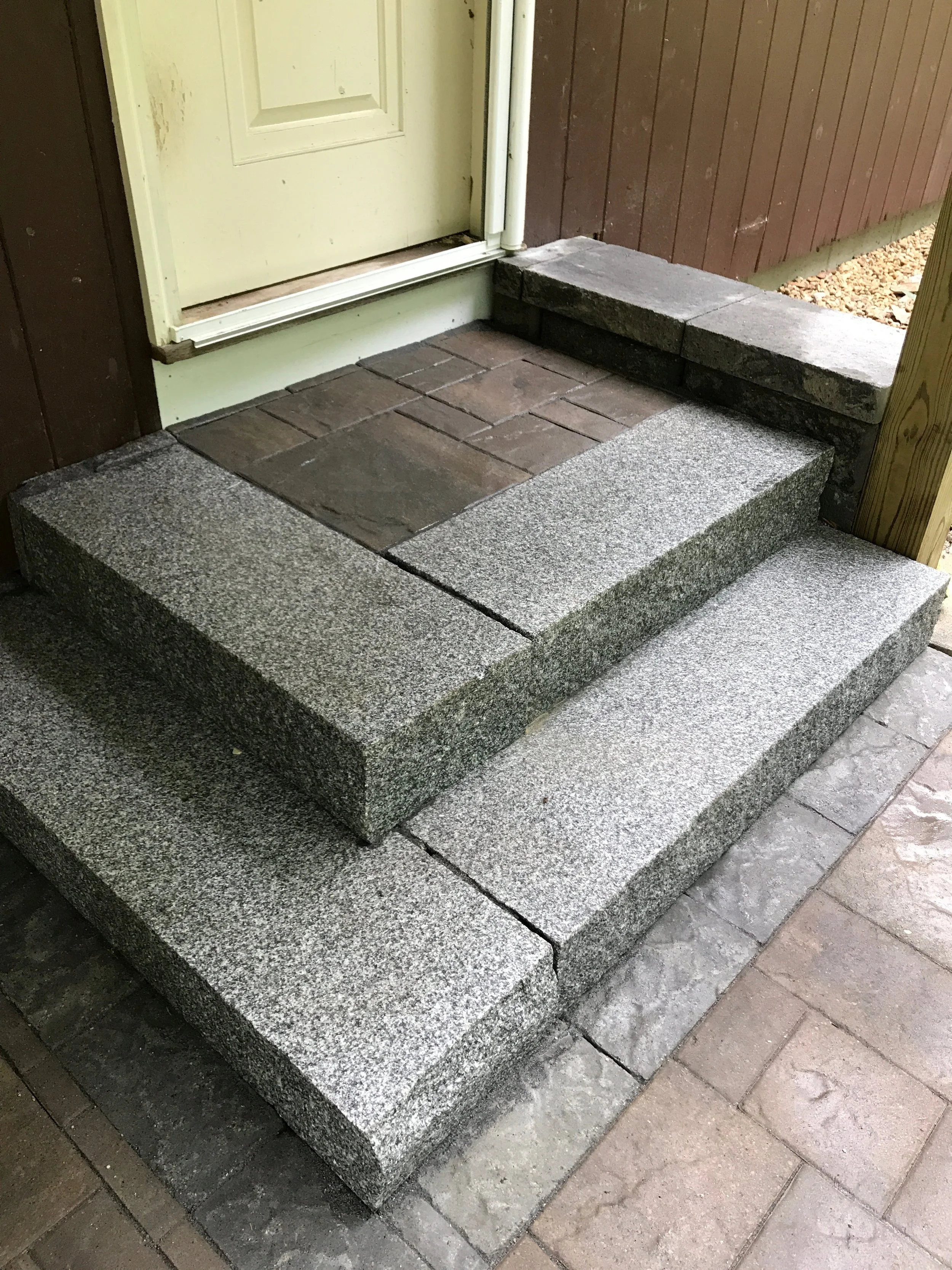 Granite and brick landing adds space to move when entering the back door of the house.