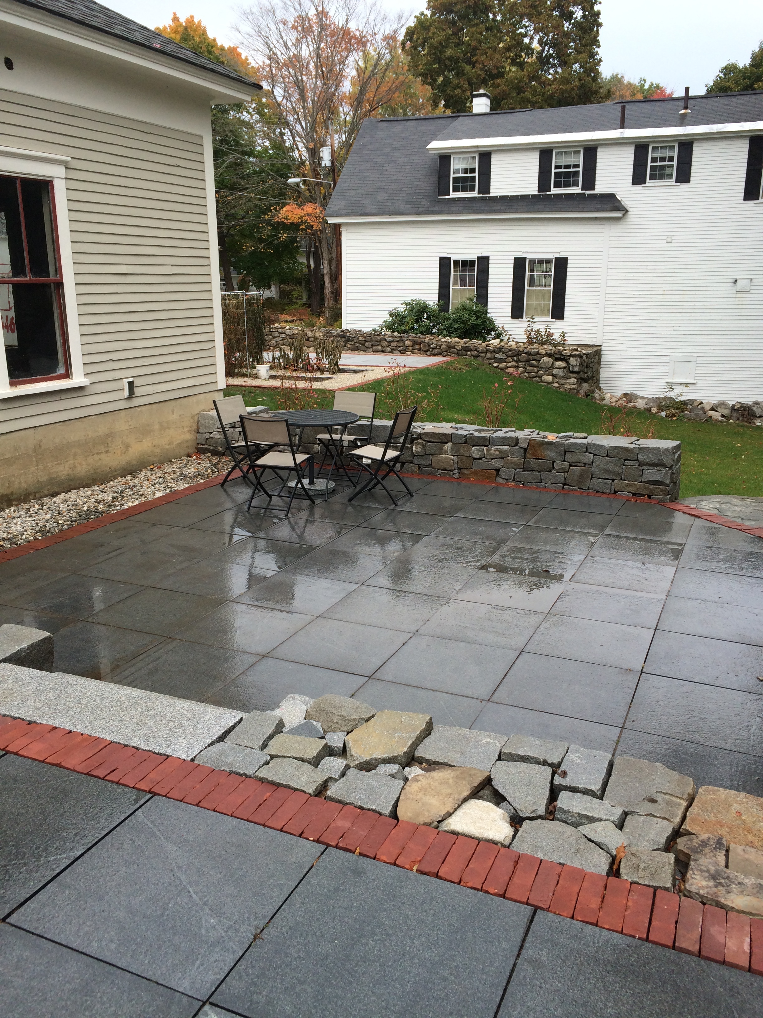 Granite 2x2 pavers with red brick soldier course, dry block walls and new steps.