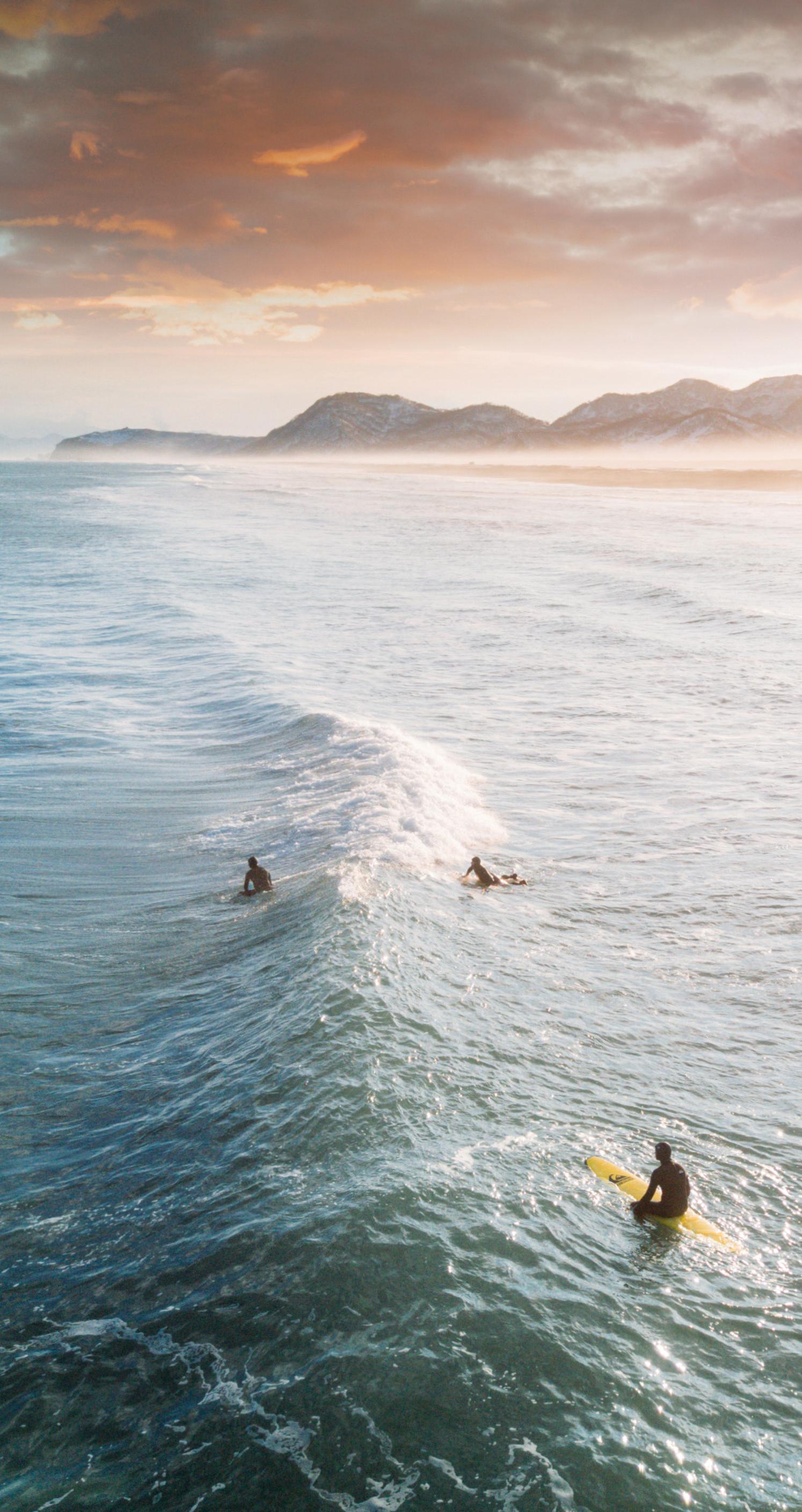 surfin at dawn pexels license https://www.pexels.com/photo/view-of-three-people-surfing-1553959/