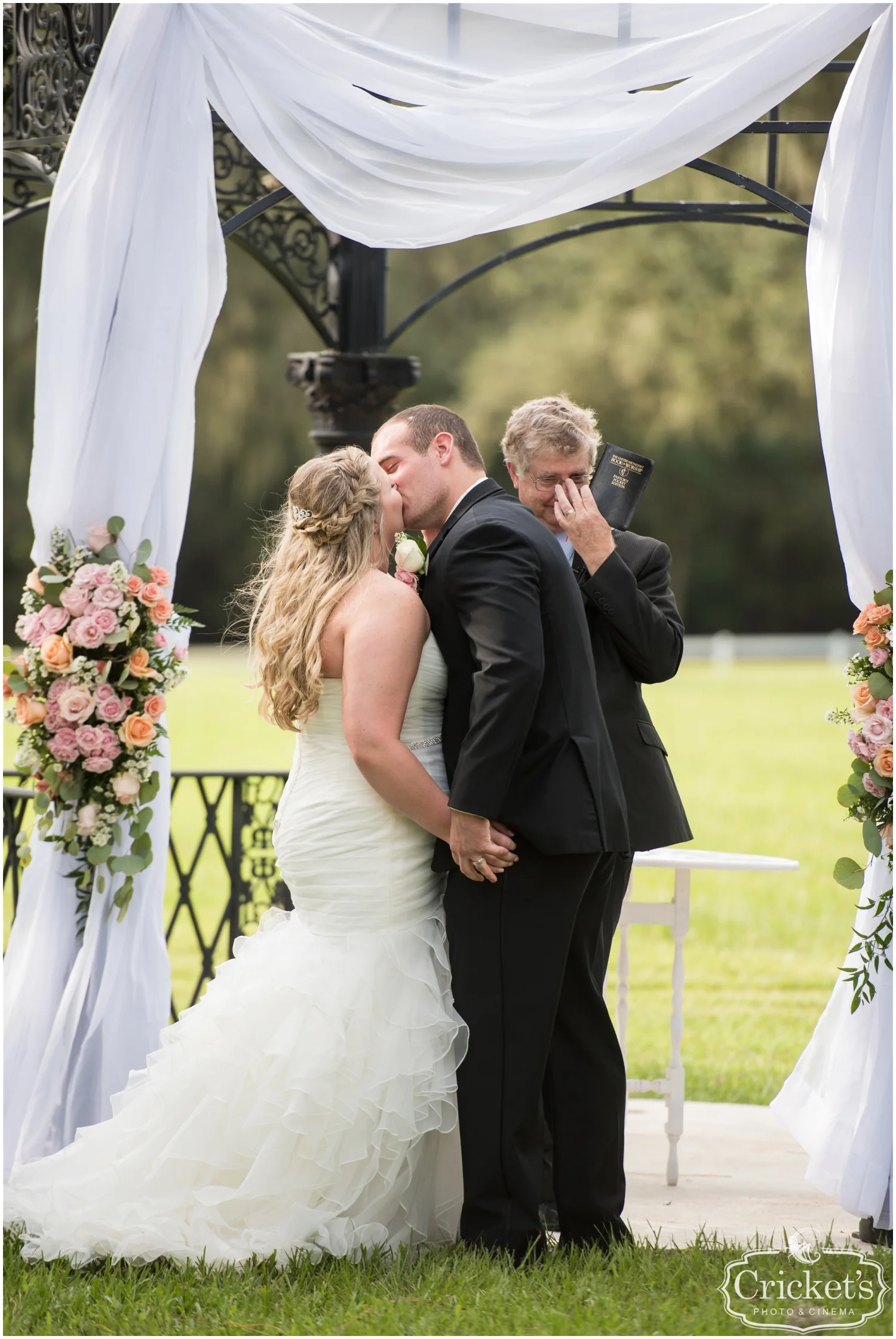 bride and groom kiss during their wedding ceremony