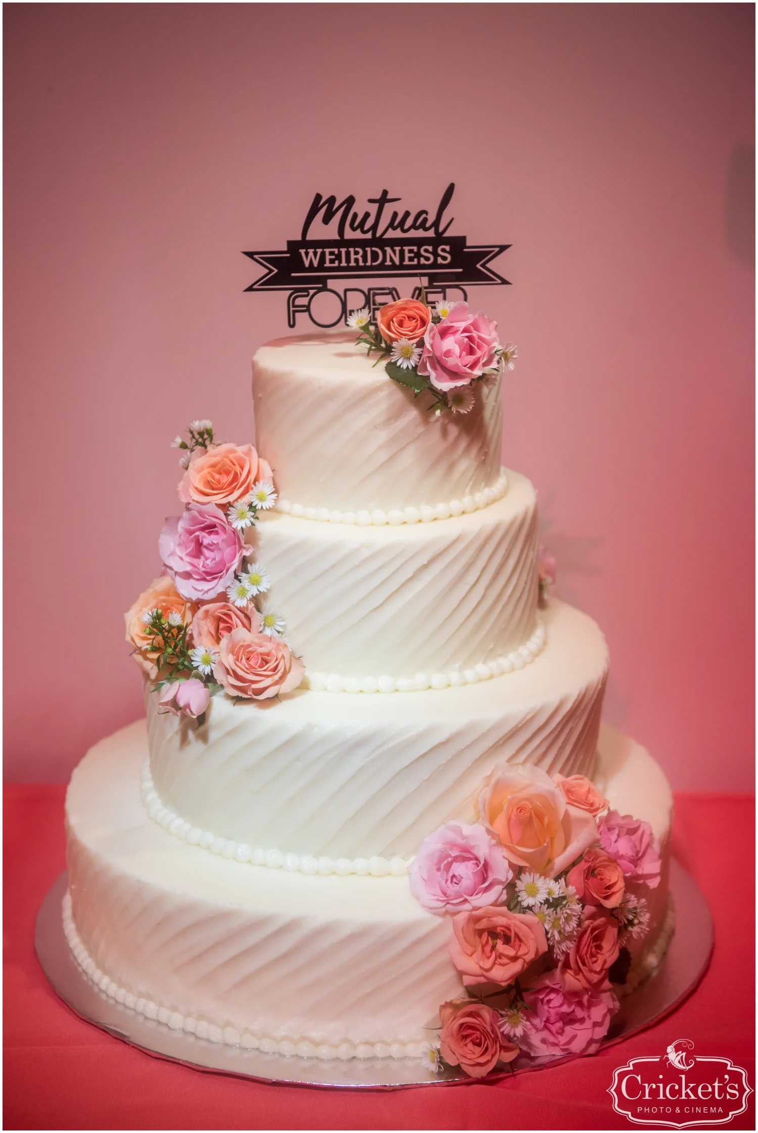 Pink floral and white wedding cake