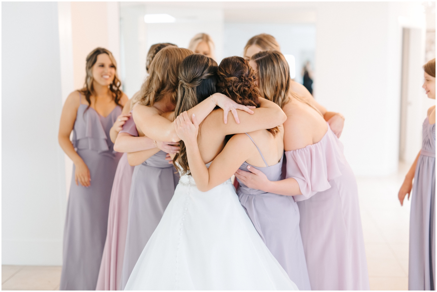 Bridesmaids hugging the Bride