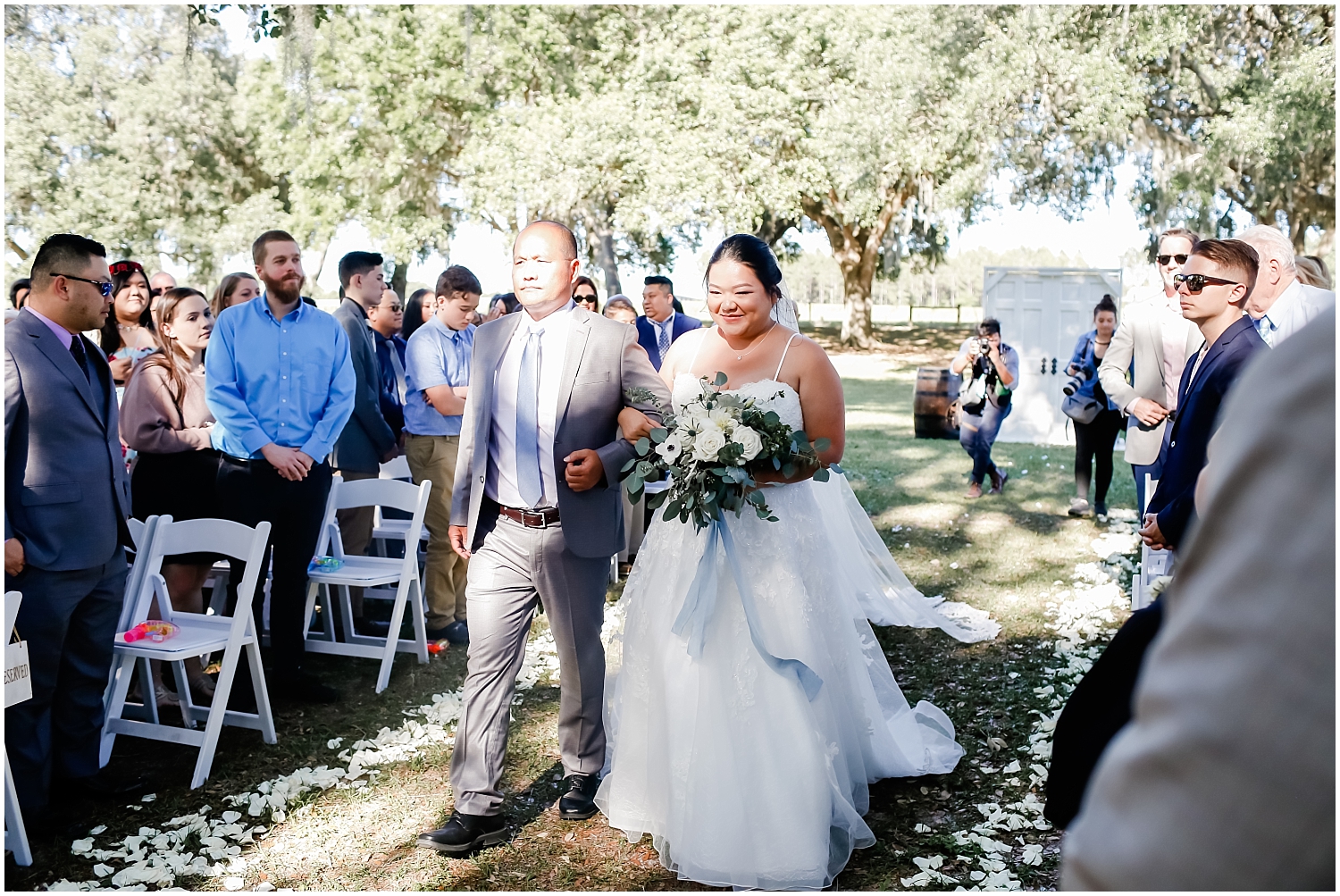 father and bride walk down the aisle