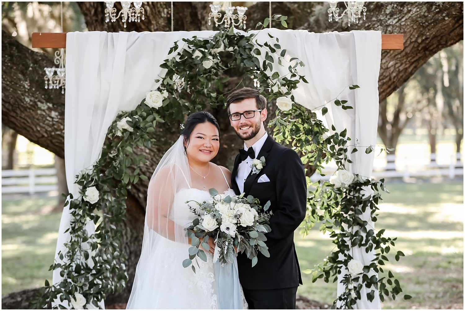 bride and groom portrait with their wedding arch