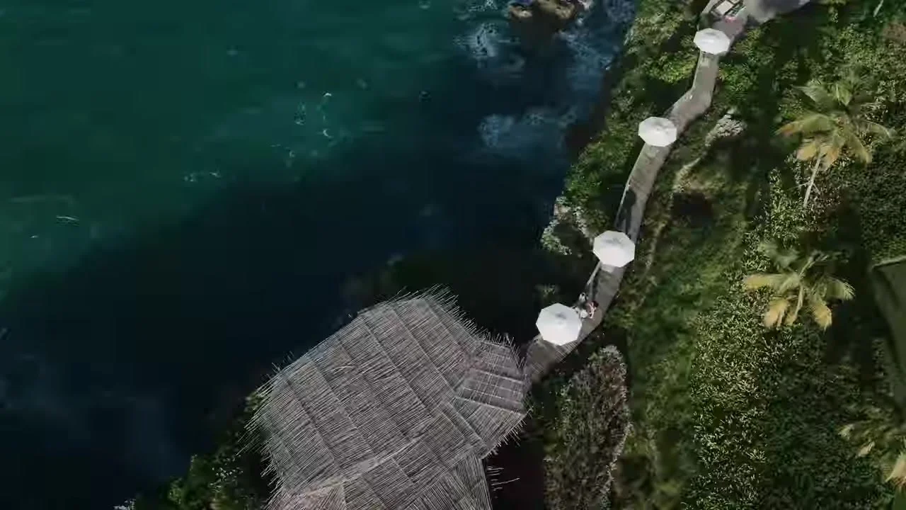 Aerial of the Amanera cliff path, white umbrellas, and the couple walking the edge