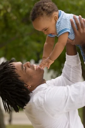 Mom throwing baby in air speaking to baby; babies learn language at Canto Speech Therapy Online