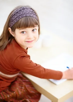 Little girl writing. Learn how kids learn to read at Canto Speech Therapy Online