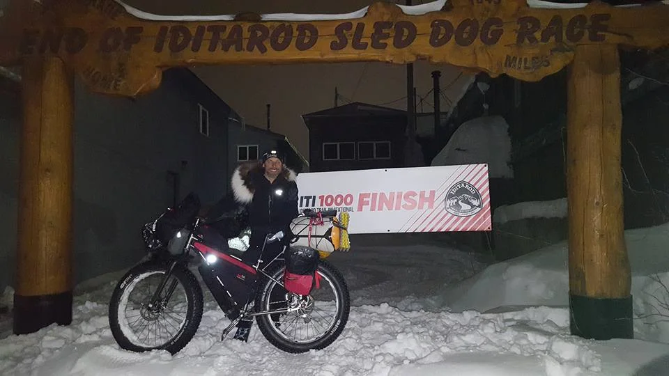 Kyle Durand under the Nome arch 1000 mile finish line
