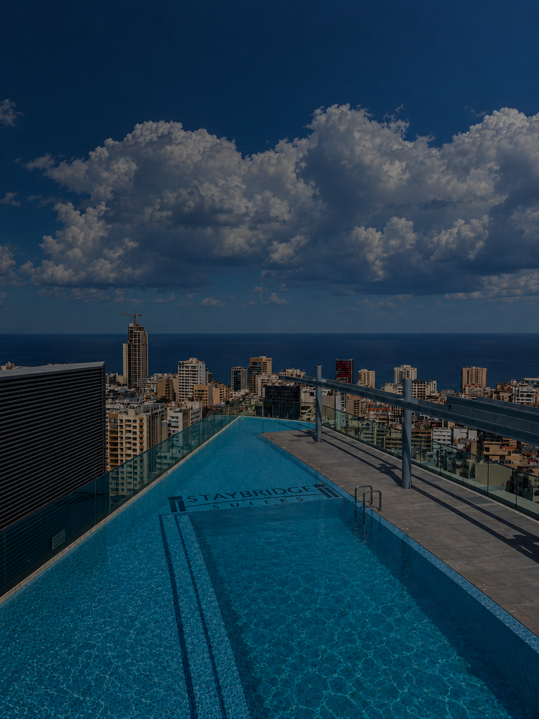 Moody Rooftop Pool Over Coastal Skyline.png