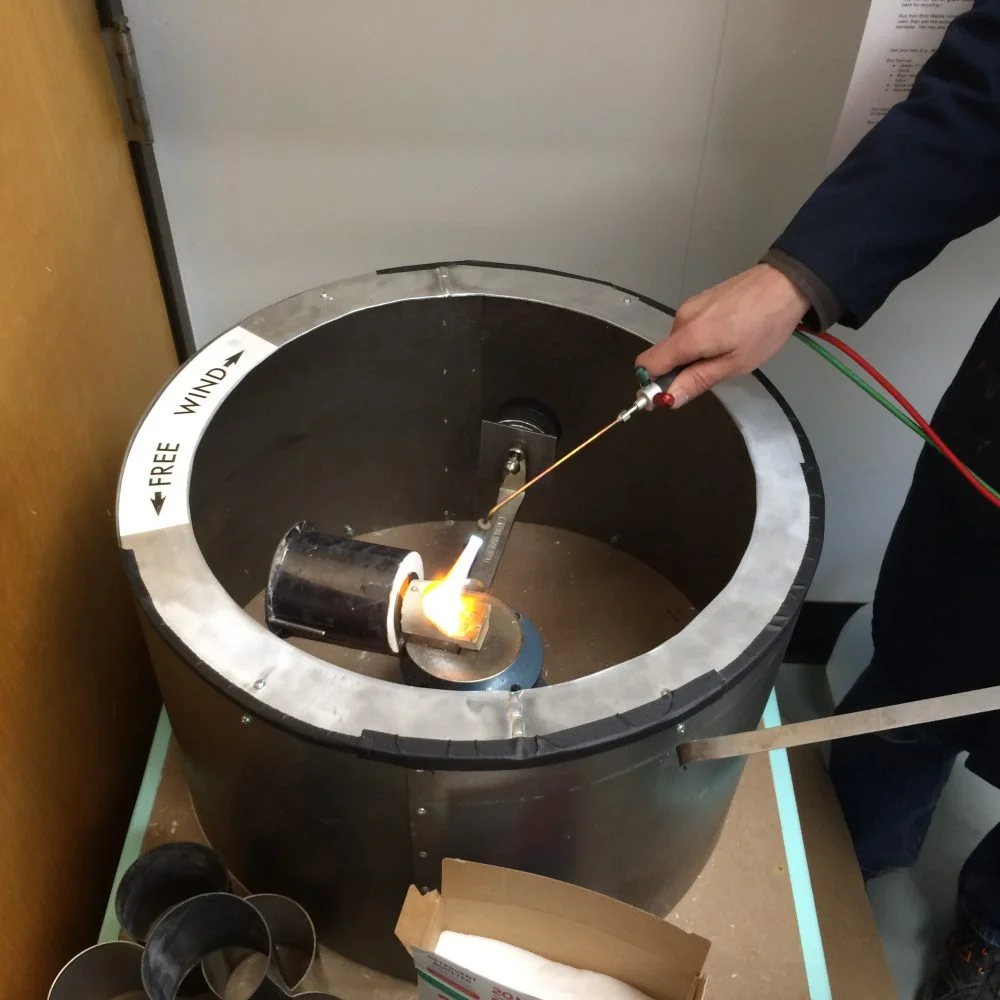 Heating up pewter in the crucible, before releasing the casting machine to spin the metal into the mold.