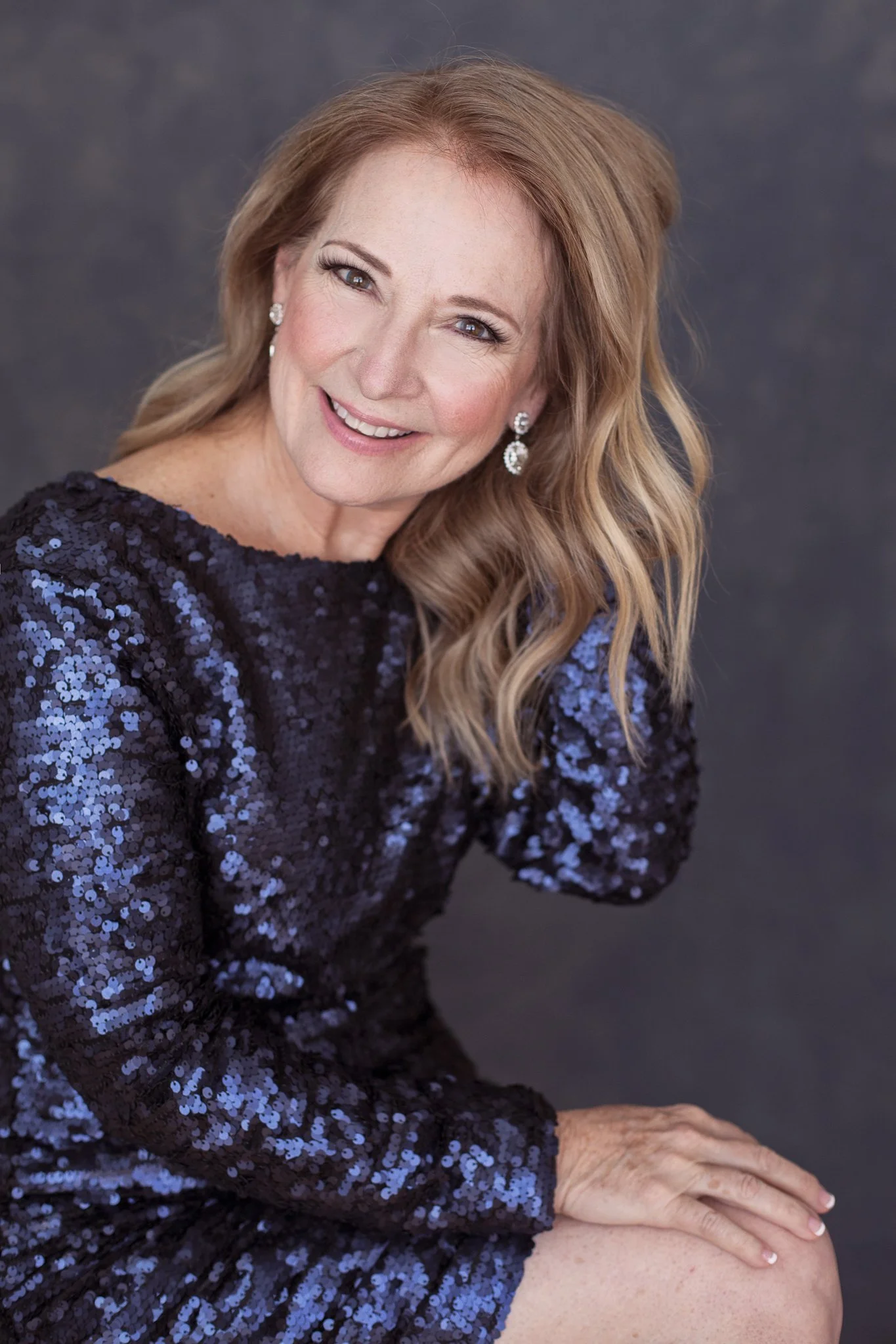 Woman in a navy sequin dress during a guided studio portrait experience.
