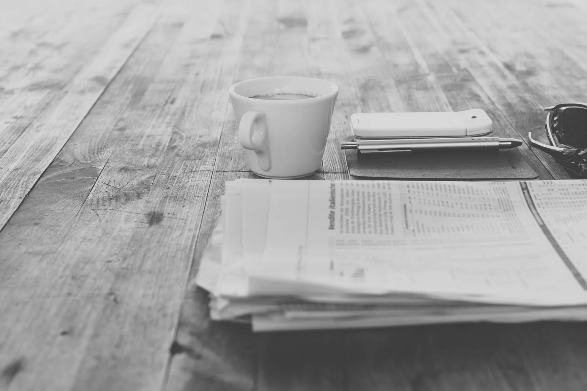 Coffee and a newspaper on a wooden table