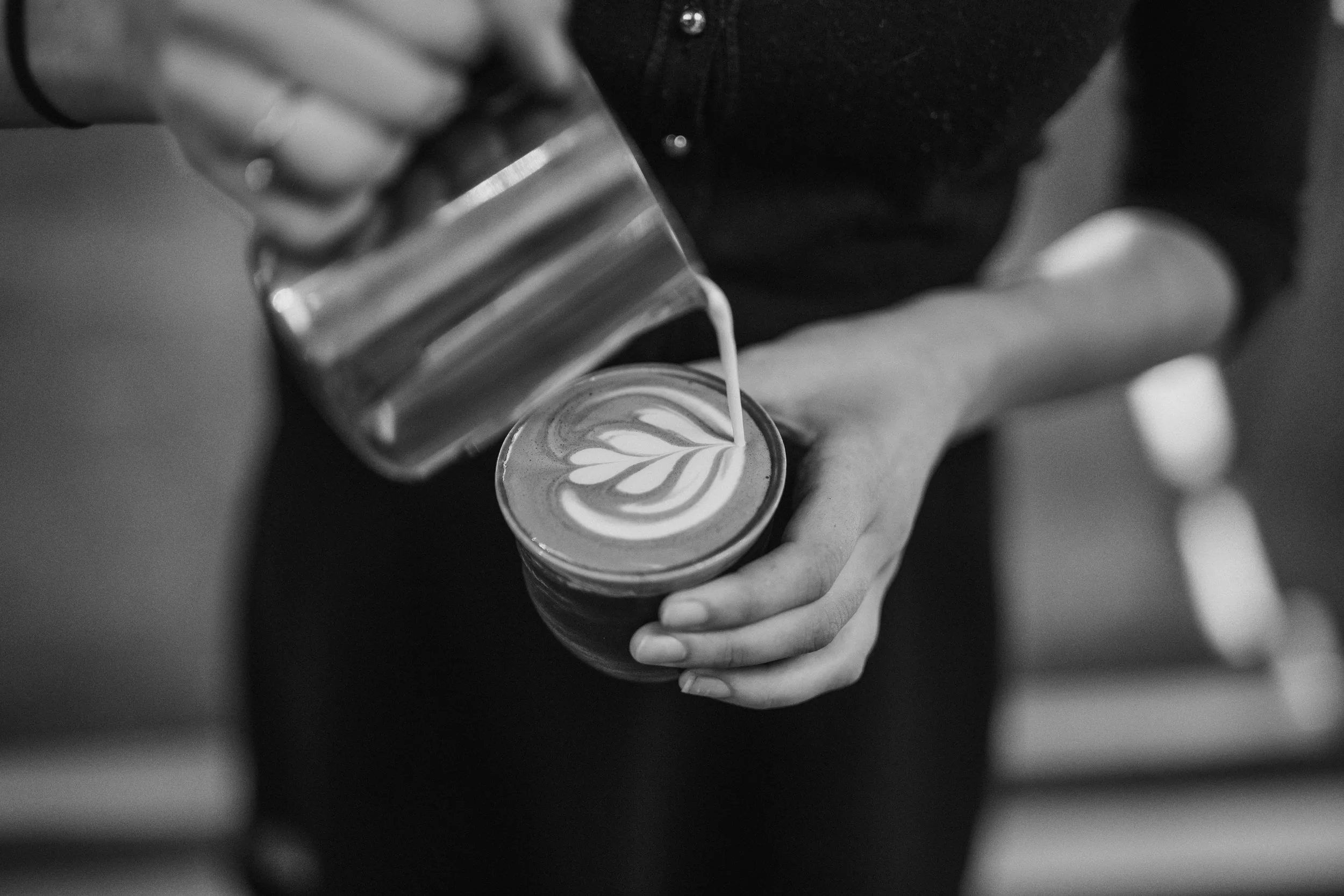 A barista pours latte art