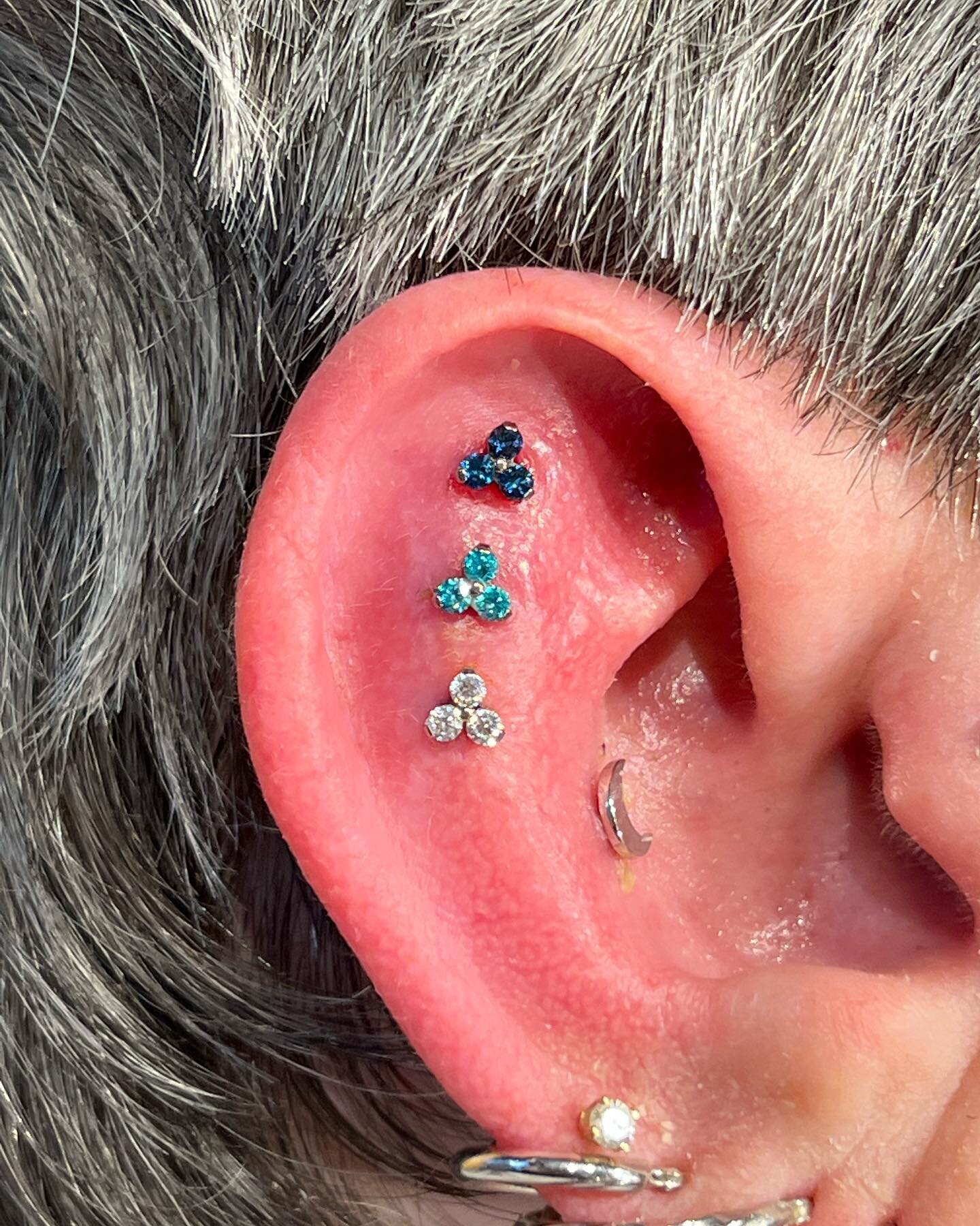 Peep this triple triple! These Scapha piercings were all done by @steeve.easley using components exclusively from @neometaljewelry 
Absolutely love the descending dark to light colors this client chose for these trinity gems!

Remember kids, if you w