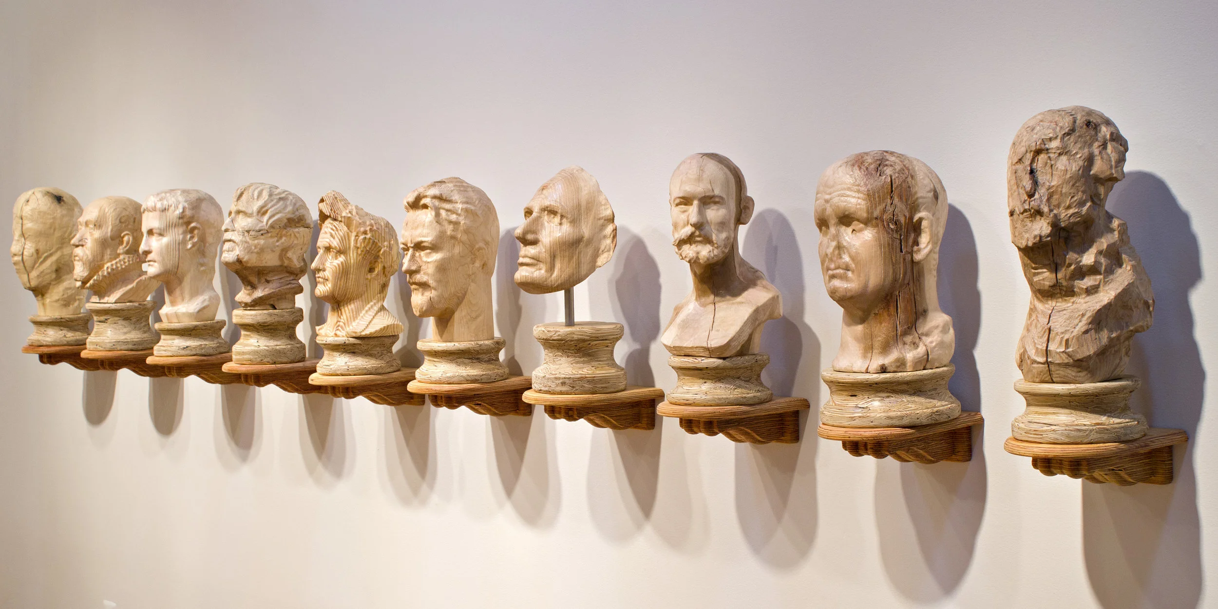 Eight Dead White Men I Found on the Internet and Two Averages , 2017. Engineered wood products, pine, oak, and poplar. Dimensions variable, this configuration 20” x 144” x 10.” The work consists of eight busts, digitally fabricated from 3D scans found on the Internet, and two ‘averages’ created by procedurally recombining the eight original busts in 3D modeling software.