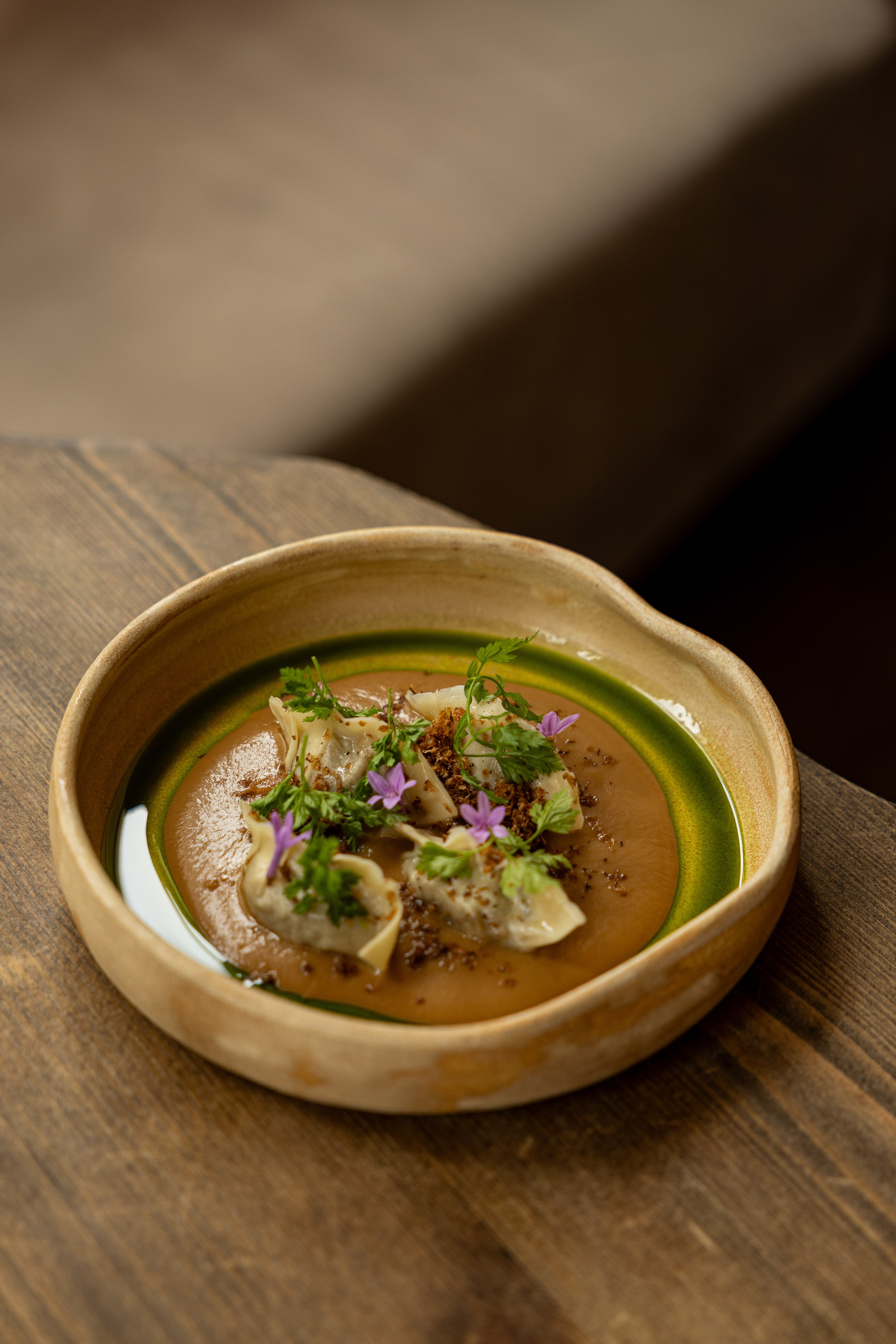 SINO_dumplings_greenoil_softlightinh_inside_onwoodentable_credit_KLYMENTIEVA VIKTORIIA.jpg