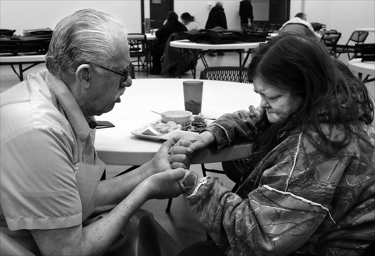 February 2017: A volunteer at the Horizons Soup Kitchen, prays with Brenda after her brother died the day before. “The Horizons Soup Kitchen helps everybody out. They prayed with me, so I would feel more calm about losing my brother. They stand behind you. If you have a depressing situation or even need help with transportation, they’re there for us like family,” Brenda said.