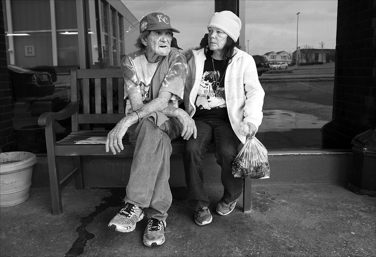 March 2017: Clarence and Vickie rest on a bench outside the $750-a-month motel. Vickie is carrying a bag of pastries she picked up at the Horizons Soup Kitchen. The couple rely on eating at the soup kitchen Monday through Friday and at Salem Church on Saturdays.