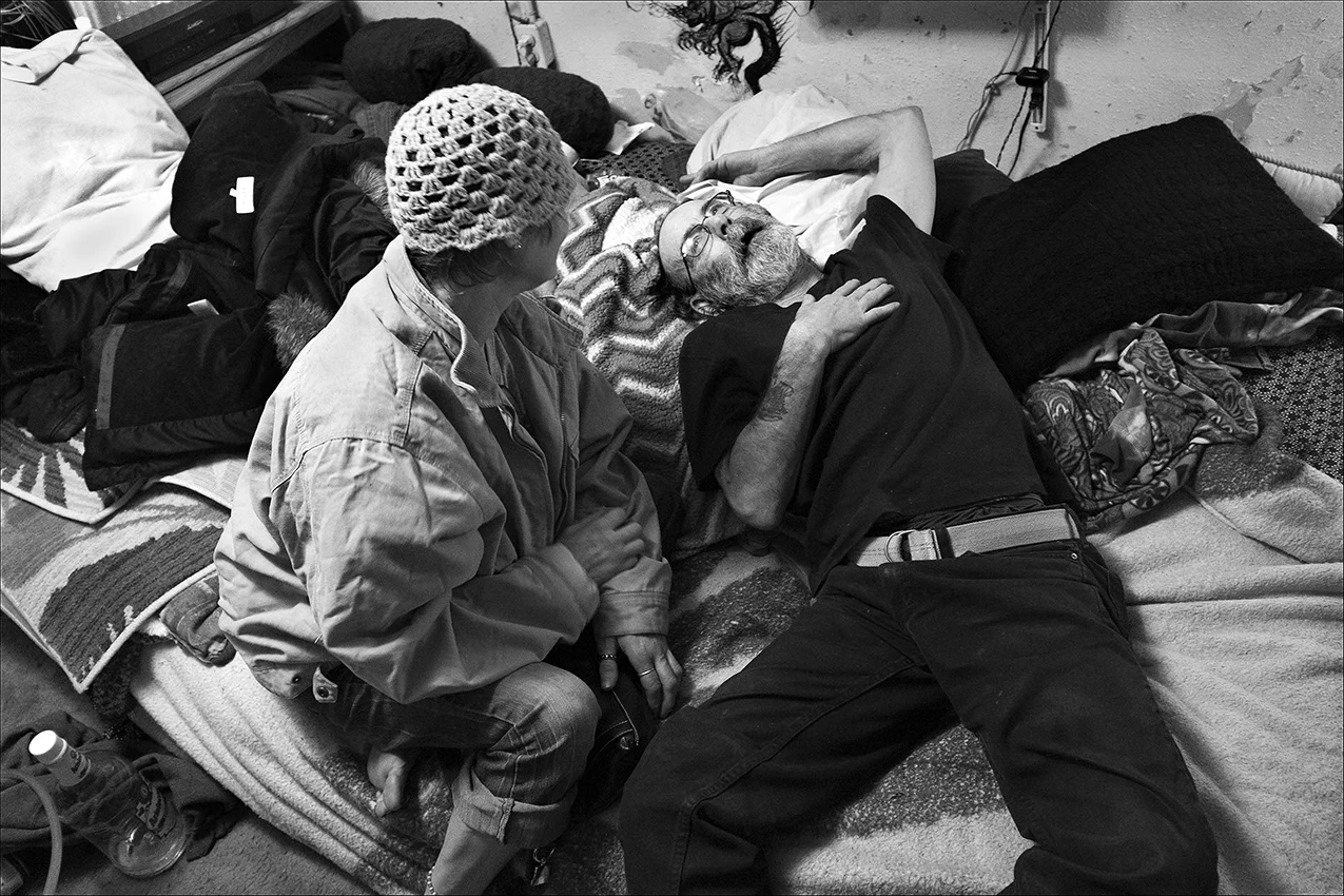 January 2017: After a long day of running errands, gathering discarded cigarettes and panhandling, Dennis shares his day with a friend living a couple of doors down the hall in his apartment complex