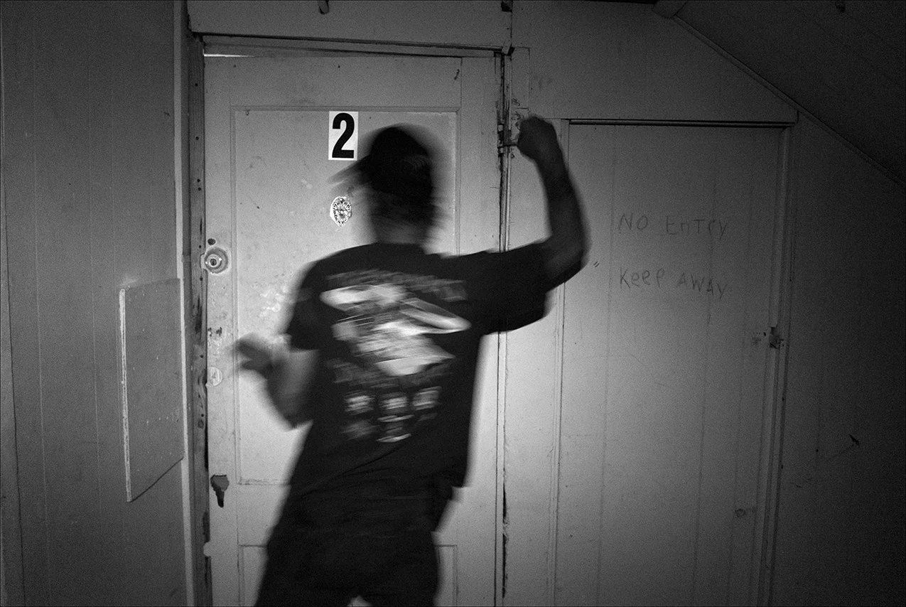 August 2017: Late one night, Dennis tries to repair the door to his apartment, but the frame isn’t square, which makes it difficult. Dennis is concerned about the possibility of someone breaking into his apartment, so he keeps his guitar in a local pawn shop, where it will be safely stored. “The traffic has slowed down. Before it was like they were all standing in line waiting to use the bathroom to shoot up. We’ll always have a dope dealer, dope people and cops chasing people through one door and out the other. That’s why I got a dog, to keep people away from my door.”