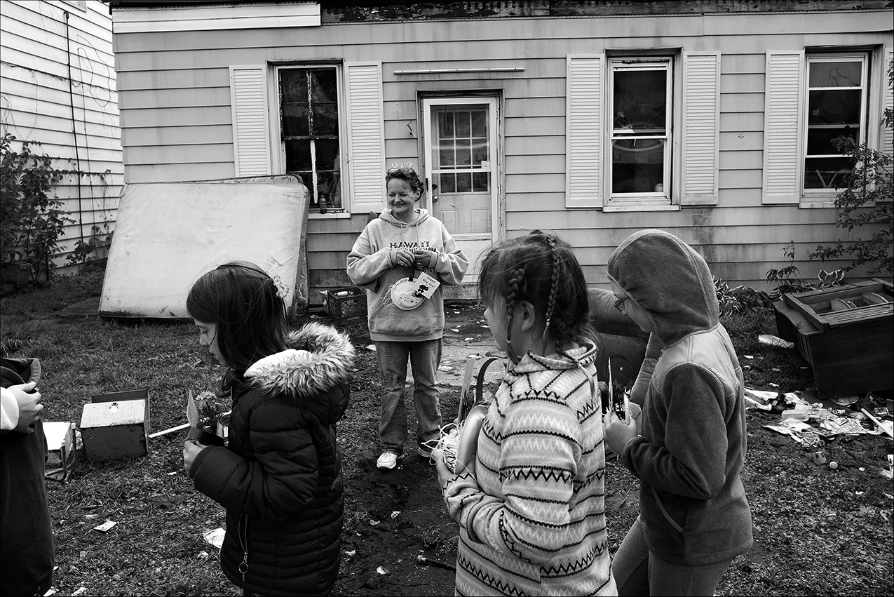 May 2017: Three days after being evicted from her home of 20 years, Berrian Elementary School third-grade students deliver May Day flowers to Elizabeth, as they have for years throughout the neighborhood. She takes a short break from gathering her belongings to bask in the memory of receiving this special blessing from the children all these years knowing this will be the last time.
