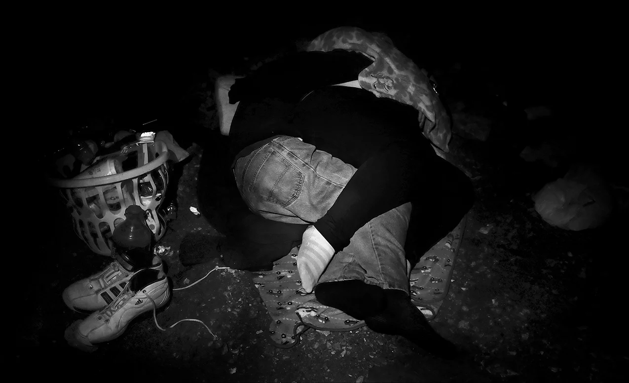 September 2016: James and a girlfriend snuggle for warmth while spending a cold, rainy fall evening sleeping under a bridge. “I’ve actually prepared and got clothes hidden now in different places so if I get wet, I know they're dry and I can go to those places and get my dry clothes. But it's difficult preparing for something like this cause with mother nature, you never know when she's gonna let go. I go through Ladies of Charity to get my clothes each month.” James says the Quincy Housing Authority (a Section 8 public housing agency) has a three month waiting list. “It’ll be winter before I can find a place to stay through them,” he says.