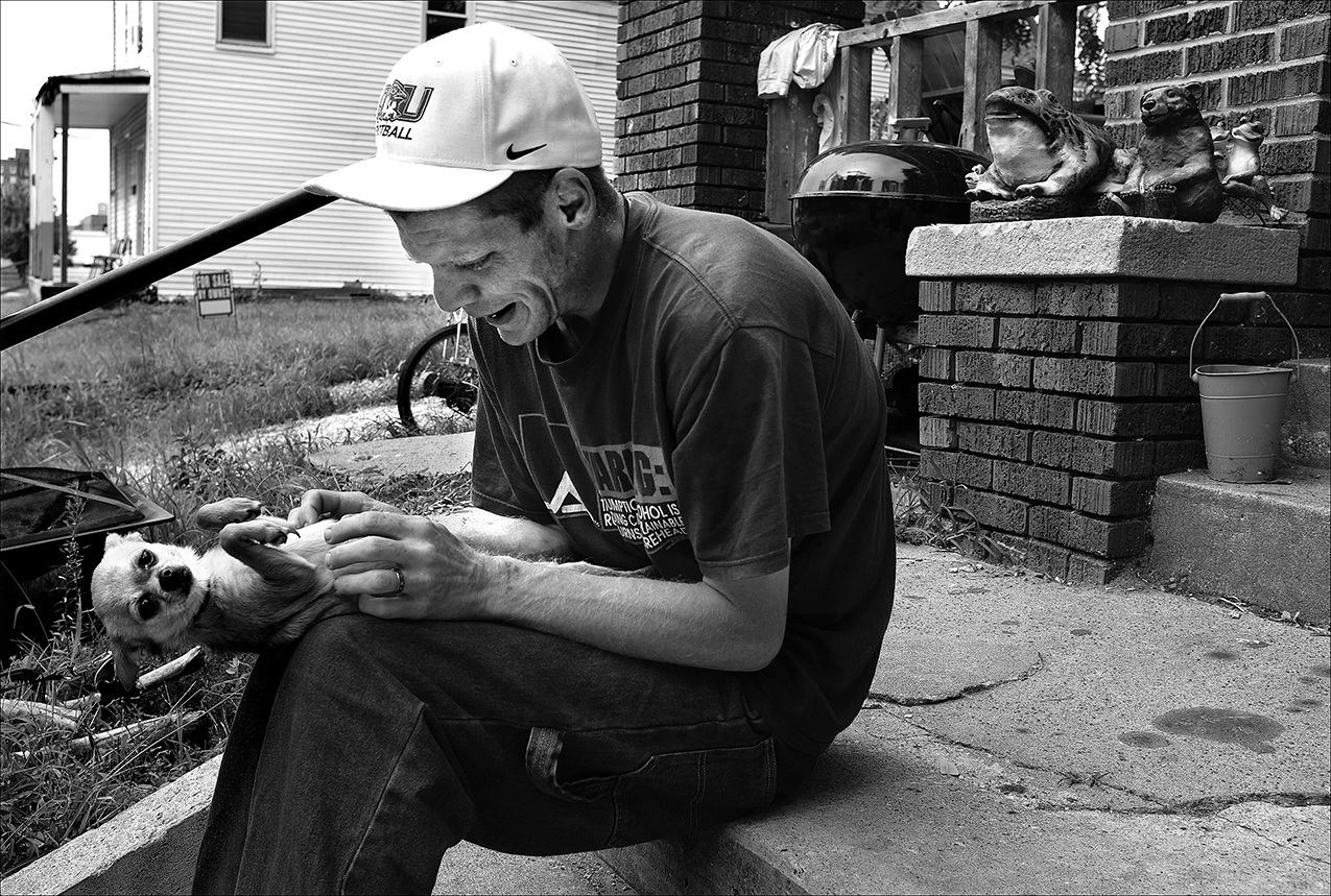 August 2016: During a break from making rounds to the food pantries in town, James takes a moment to play with a friend’s dog. James says he likes to write poems, but then his depression kicks in and his whole mood changes. “My mood goes from upbeat to down low, almost suicidal thoughts,” he says.
