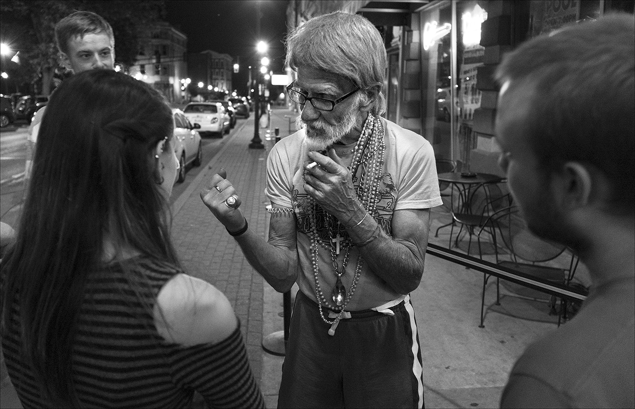 May 2017: Walter stops to talk with a group of college students outside a bar across from Washington Park. They are intrigued by his stories.