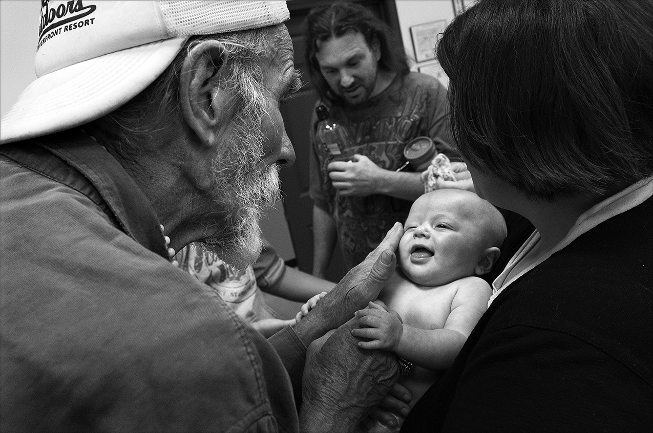 May 2017: While waiting in line to eat lunch, Walter plays with an infant, an interaction that raises his spirits after being homeless for five days.