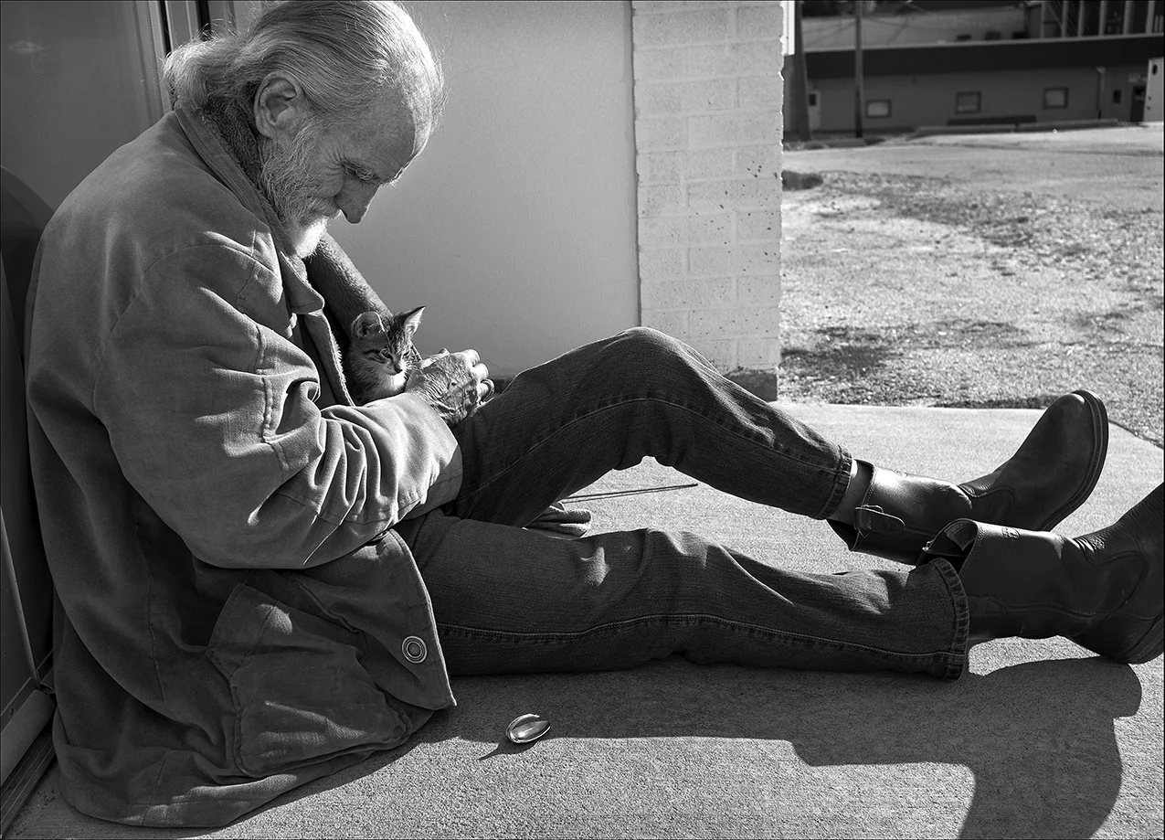 October 2017: Walter waits in the warm sunlight with his new kitten outside the doors of the Horizons Soup Kitchen in Quincy. A few days later he found the kitten dead in his yard.