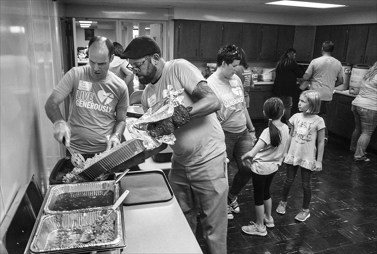 Quincy Chef Pete Maggliocco, center, loads up the pulled pork during a dinner party held for those who struggle making ends meet, Sunday, Sept. 23, 2018 at Luther Memorial Church in Quincy, Illinois.