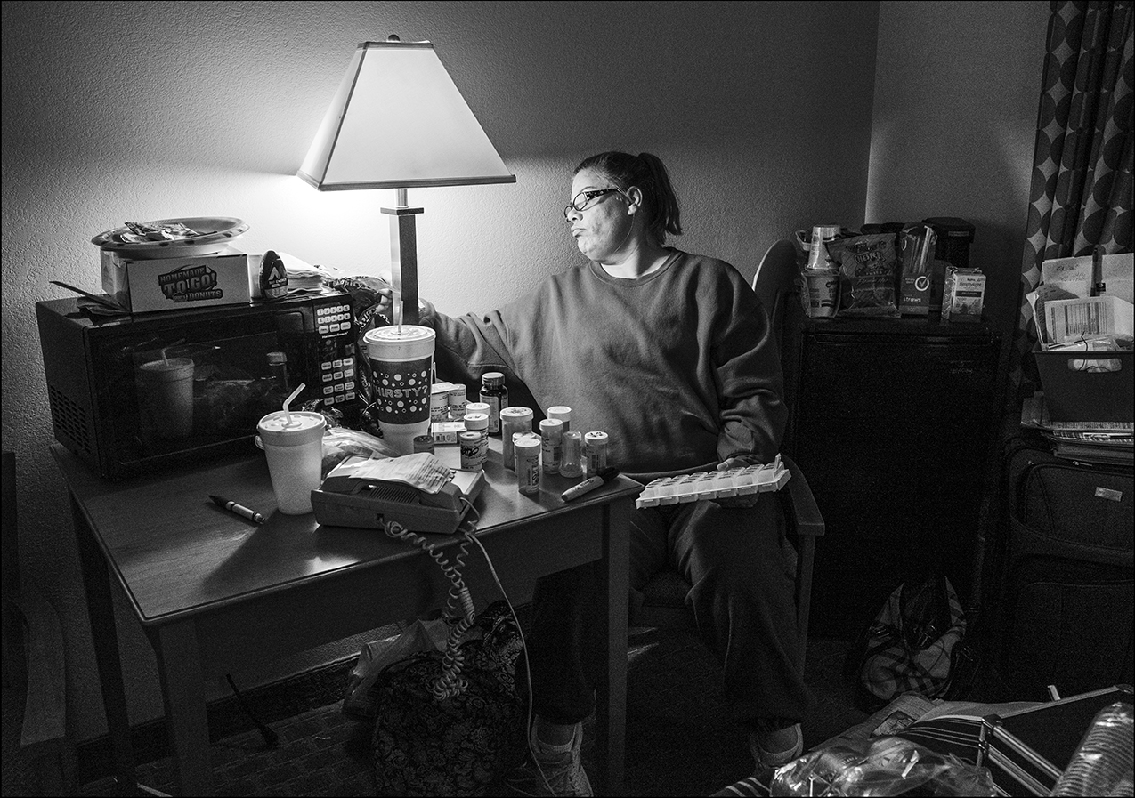 November 27, 2018: Homeless. After a full day of searching for housing and emergency shelter assistance, Becky sorts and prepares her paraplegic son’s 20 different types of daily medication, Tuesday, Nov. 27, 2018, at the Comfort Inn in Quincy. With no emergency shelter opportunities available in Quincy, Becky and her two sons are relying on people who have generously paid for her motel room through December the 9th, after learning of her plight on the Quincy Illinois Poverty Project Face Book page. As of today, December, 6, 2018, the family’s future is uncertain.