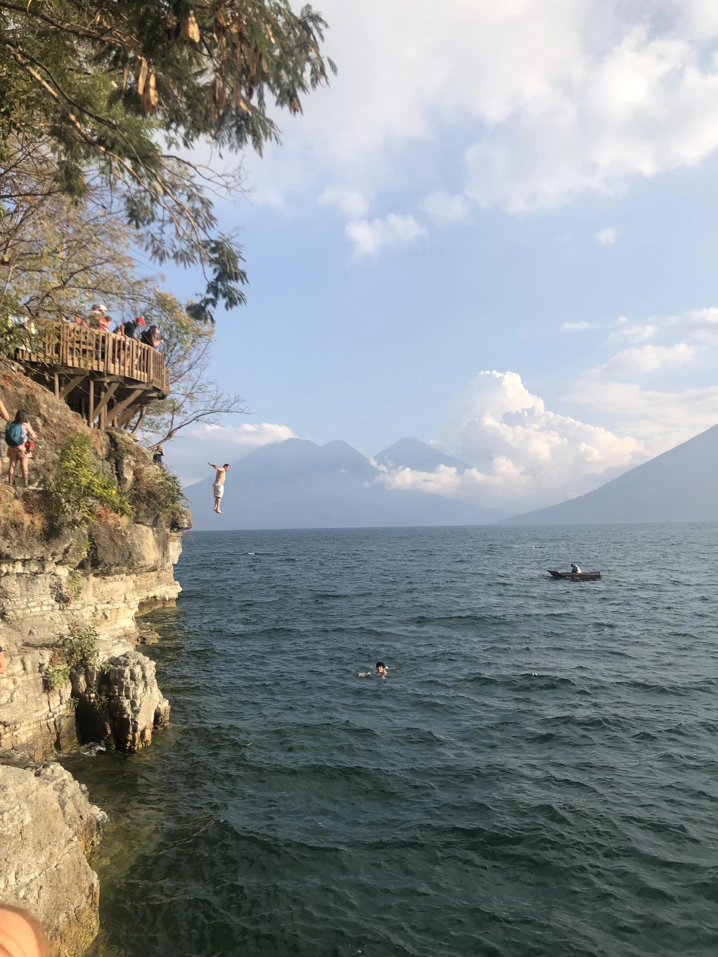 A man jumps off the trampoline into the water