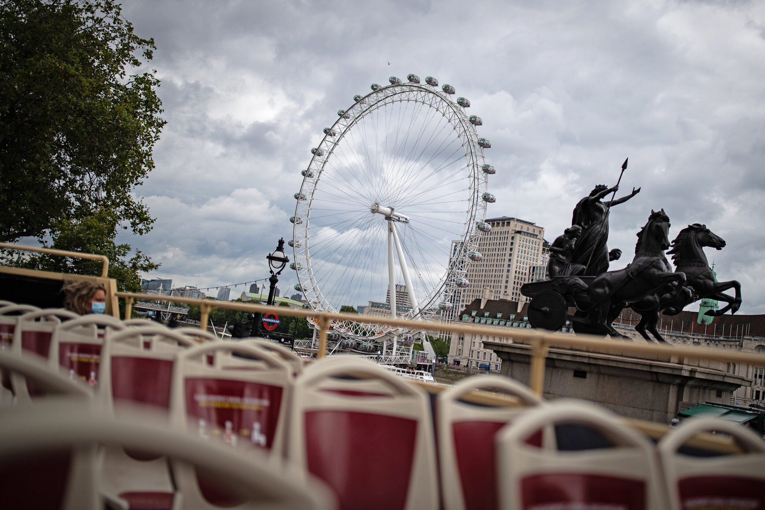  Tourists on a near empty top deck on the London Big Bus open-top tour as it passes The London Eye in London. Picture by: Aaron Chown/PA Images. Date taken: 23-Aug-2020 