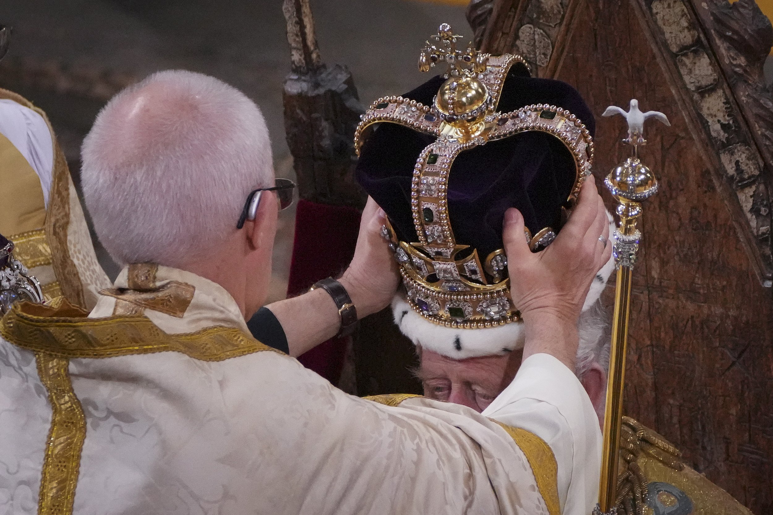  King Charles III, seated in St Edward's Chair, also known as the Coronation Chair, is crowned with St Edward's Crown by The Archbishop of Canterbury the Most Reverend Justin Welby during his coronation ceremony in Westminster Abbey, London. The King