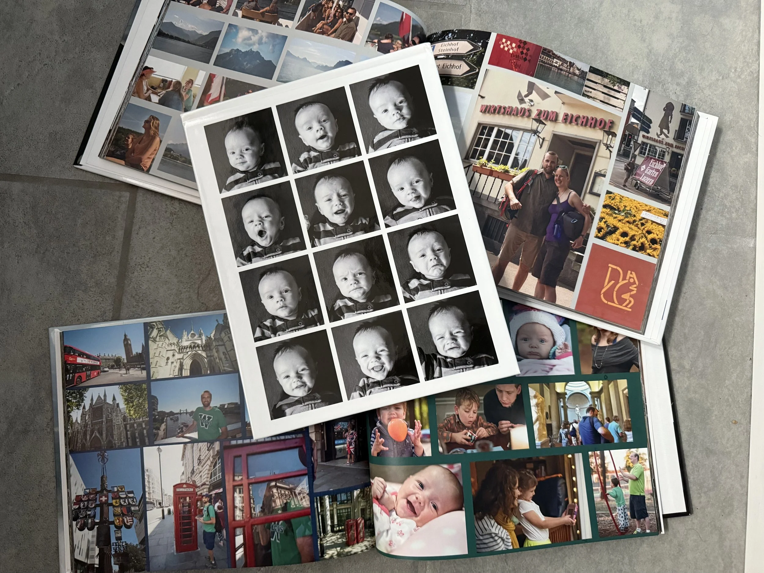 three photo albums, two laying open to photos of travel and family adventures. One on top with a series of 12 images of a baby making different facial expressions.