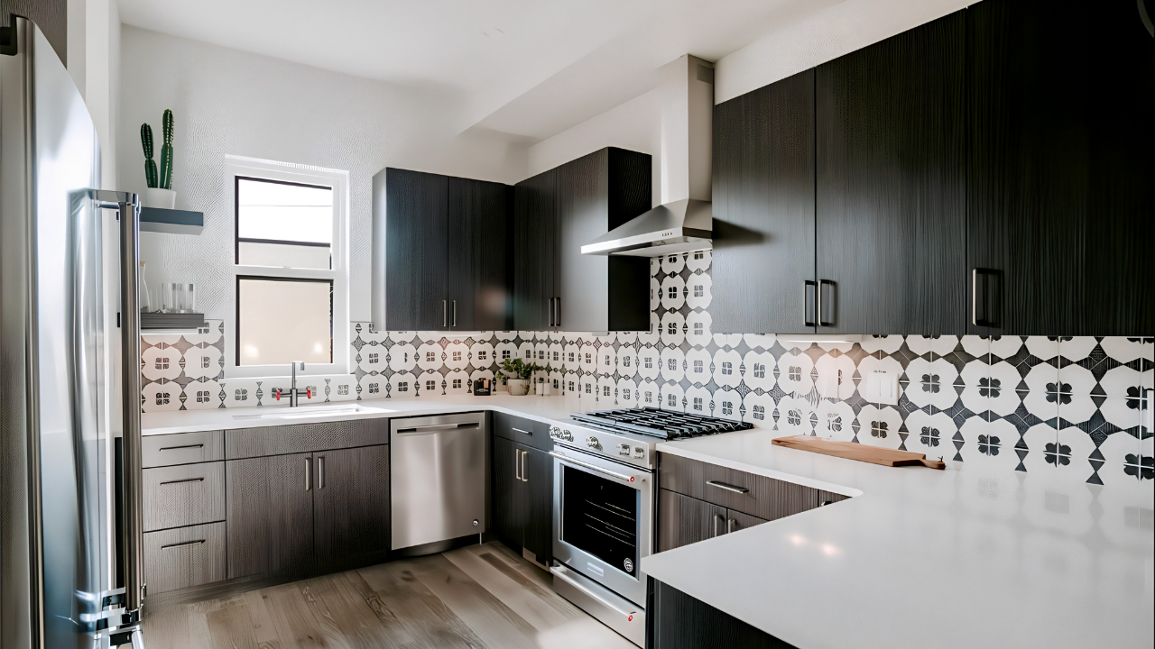 Modern kitchen with dark cabinets, white countertops, a patterned backsplash, and stainless steel appliances.