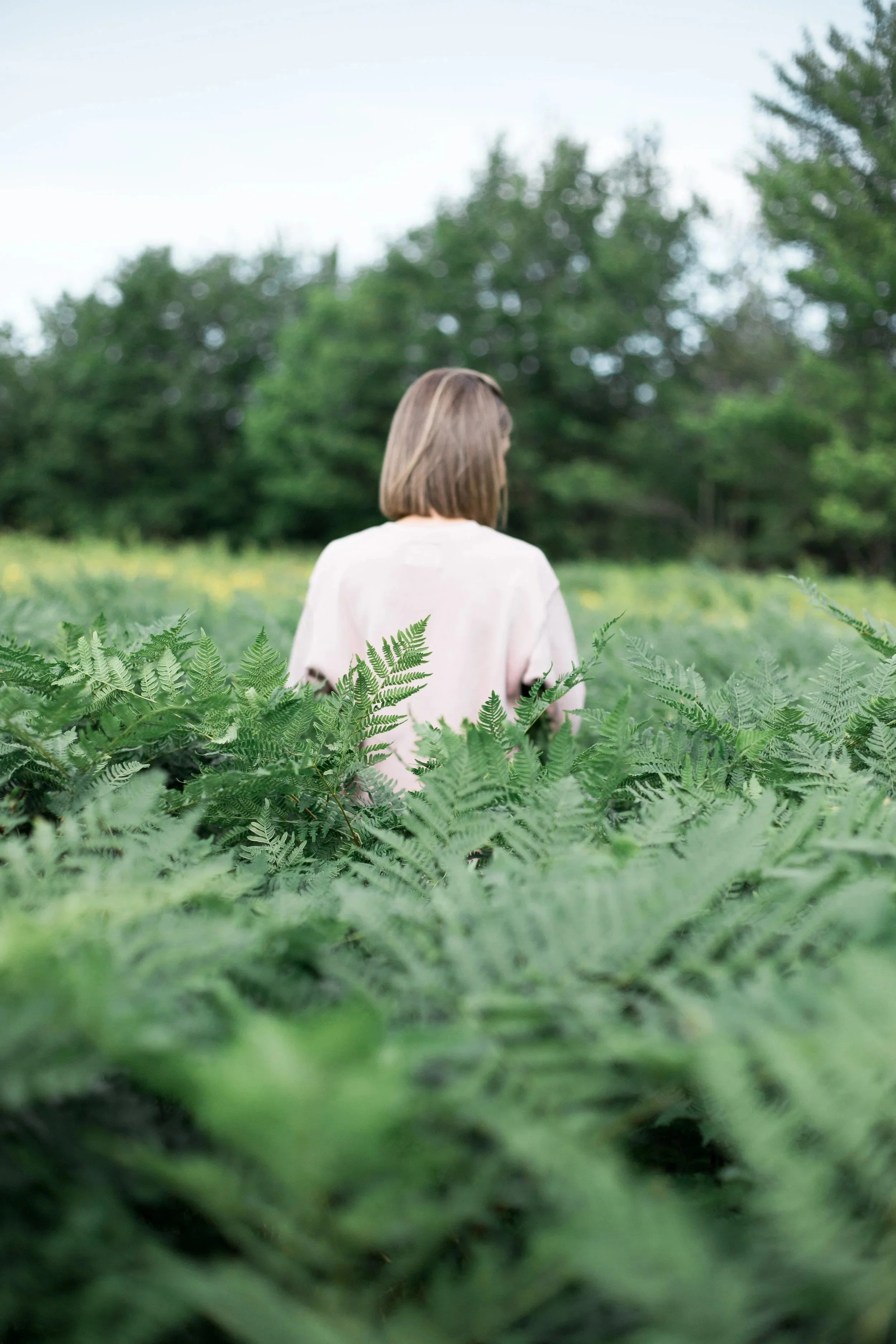 portrait femme de dos dans champ de fougère