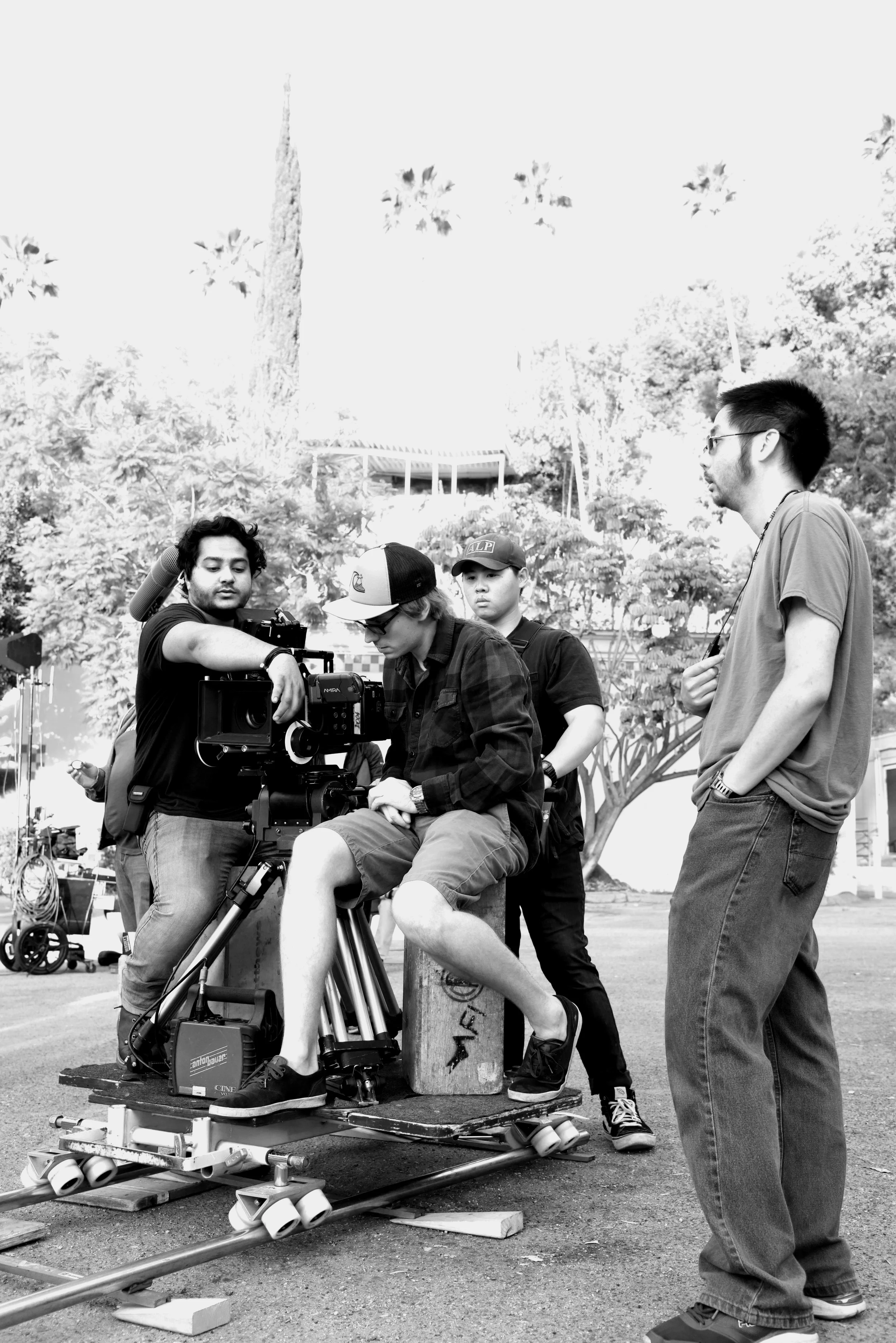 1st AC Sam Chatterjee sets focus for a dolly shot with DP Michal Wronski and 1st AD Kevin Huie .
