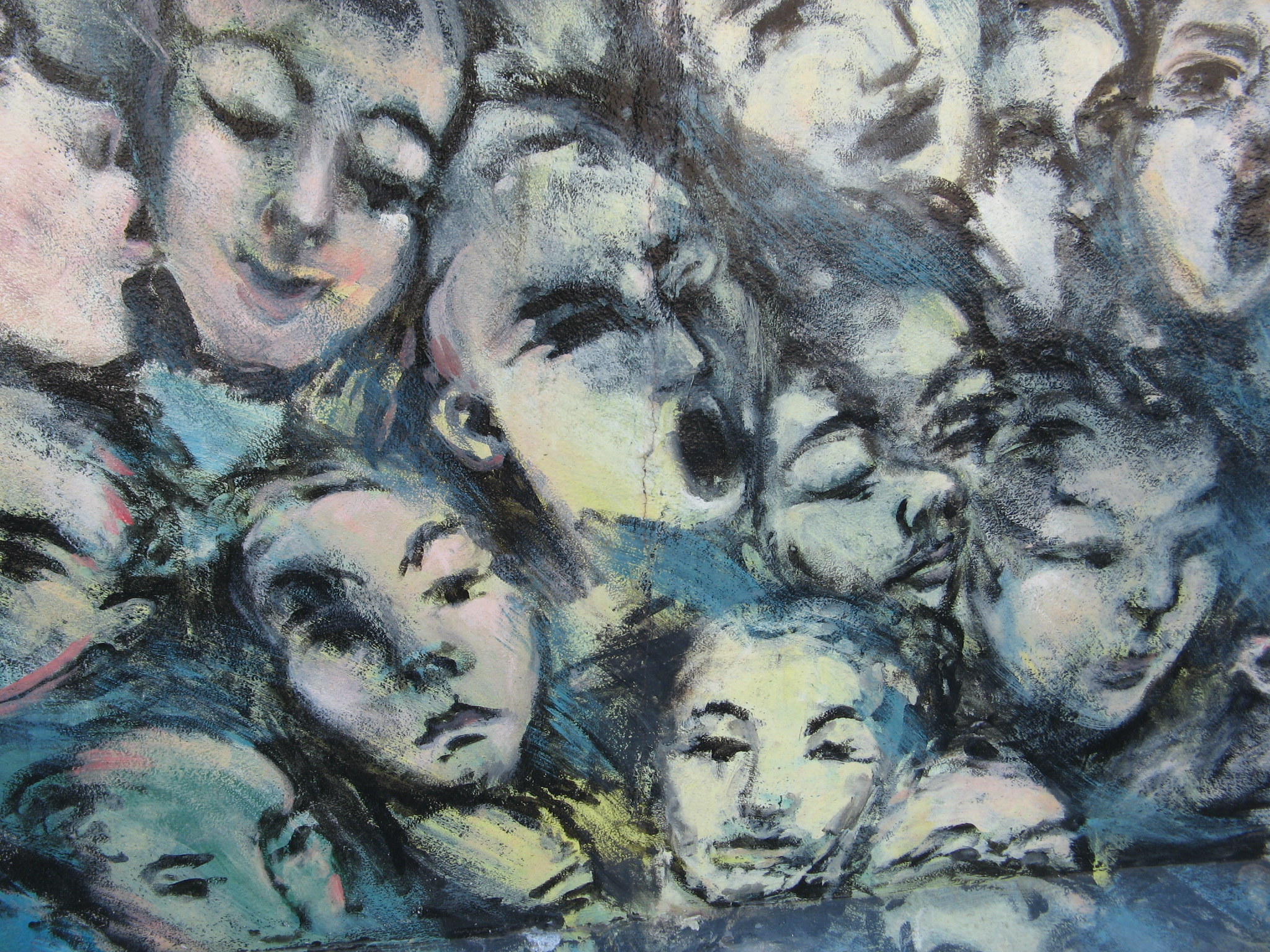 Close up of expressive faces artwork at the Mauer Museum, Berlin Wall, Germany.