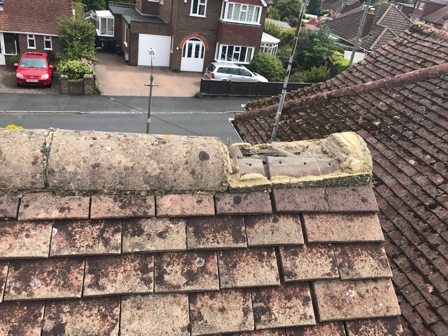 Failed mortar bedding and displaced ridge tile on a Sussex plain-tiled roof