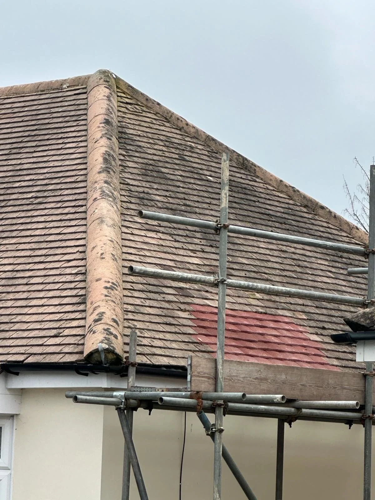 Weathered tiled roof slope inspected at close range